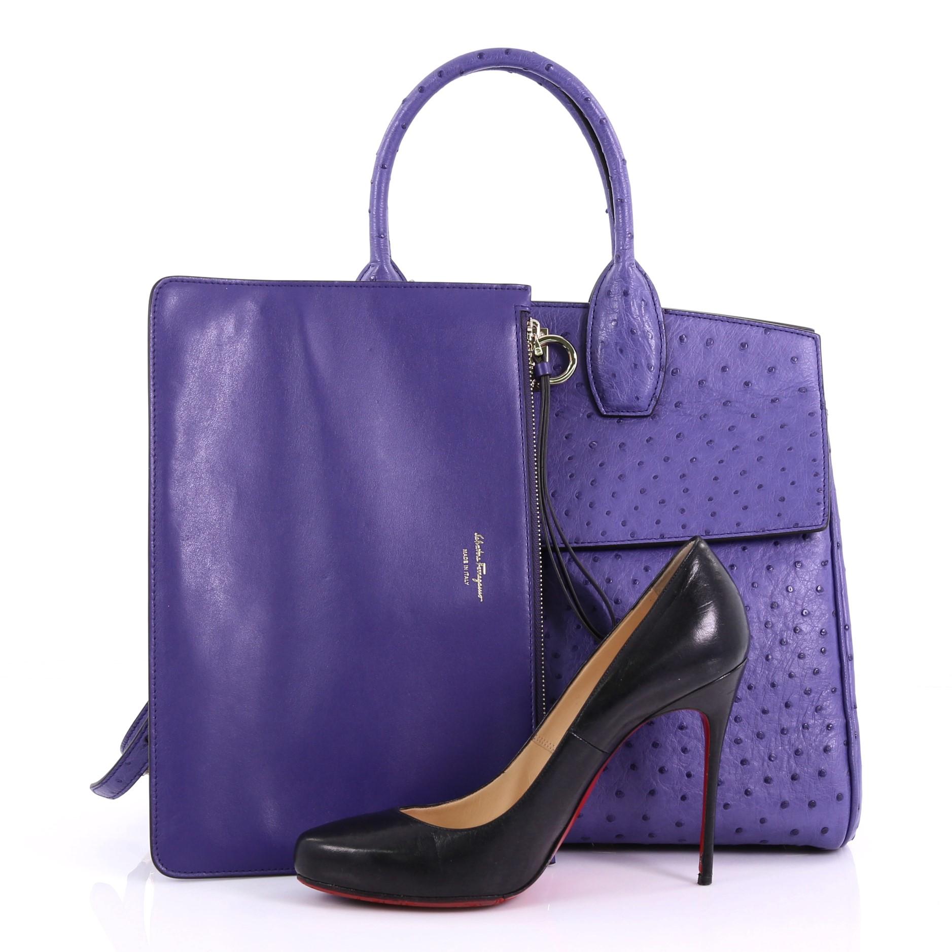 This Salvatore Ferragamo Studio Satchel Ostrich Medium, crafted in genuine purple ostrich, features dual rolled leather handles, Gancini closure, studded base, zip pocket under flap and gold-tone hardware. Its Gancini closure opens to a purple