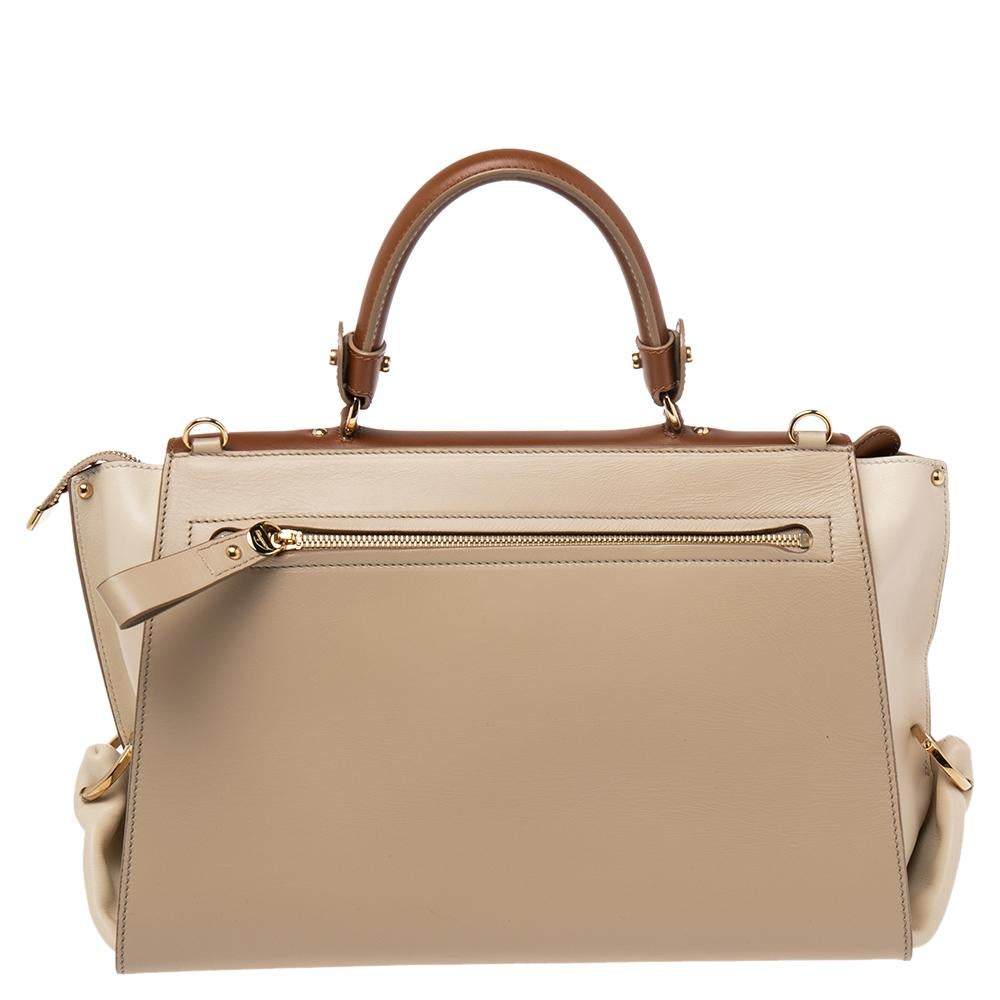 Carry this gorgeous Salvatore Ferragamo Sofia bag wherever you go. Meticulously crafted from tricolored leather, this bag has been styled with a top handle, a removable shoulder strap, and a suede and leather interior to hold all your
