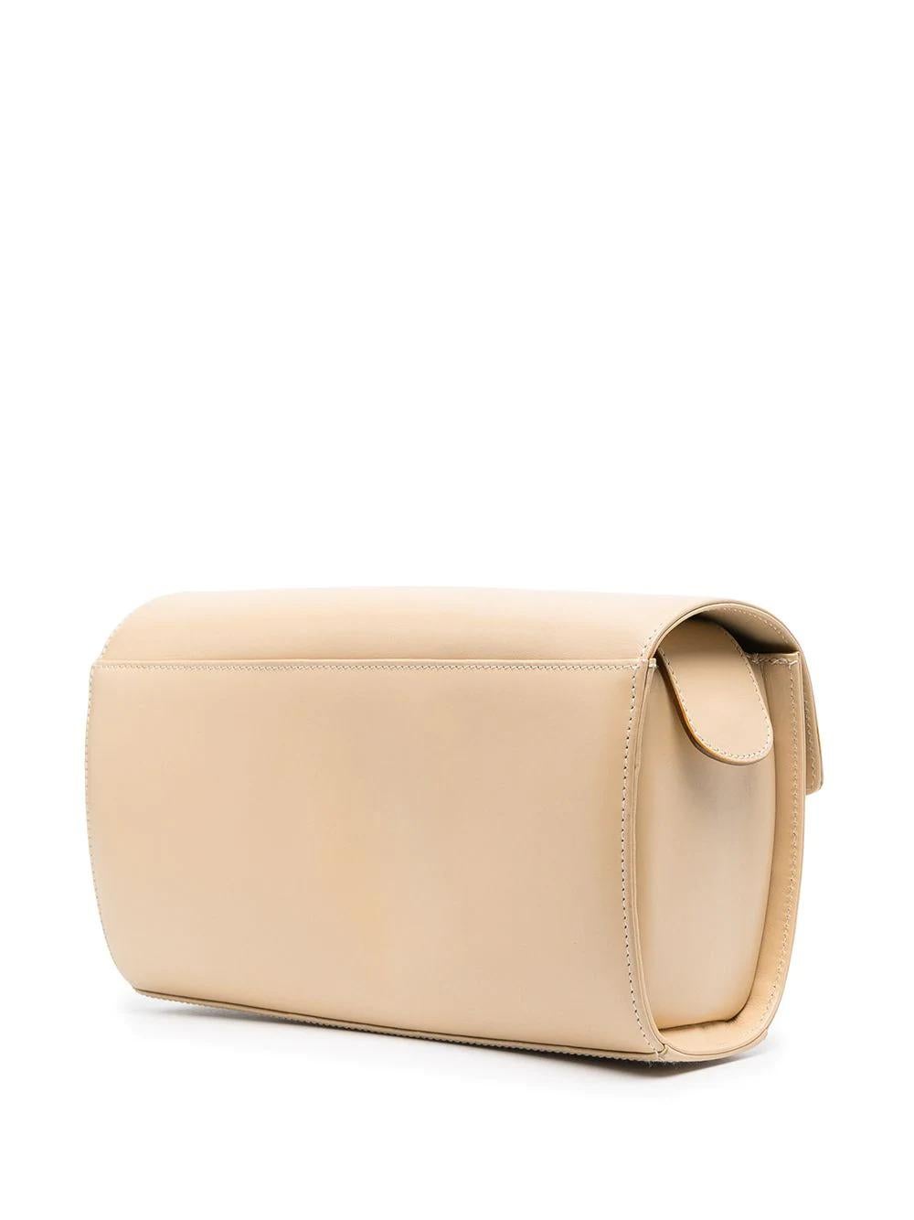 With an unfettered silhouette and an understated beige leather facade, this Ferragamo shoulder bag exudes quiet luxury and Italianate craftsmanship. Featuring Ferragamo-embossed gold-tone buckles, it is a perfect companion piece for evening wear, or