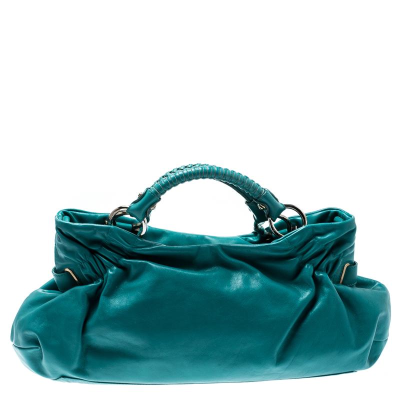 Salvatore Ferragamo's Ottavia satchel bag has a fresh and adorable style. Made from turquoise leather, the bag has a simple design. It features dual rolled handles, top zip closure, and silver tone hardware. It has a spacious interior and can carry