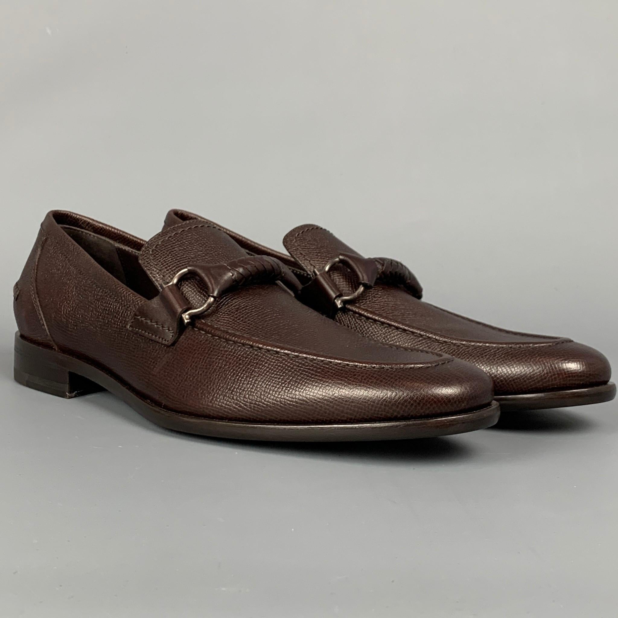 SALVATORE FERRAGAMO loafers comes in a dark brown pebble leather featuring a signature braided gancini bit strap, slip on style, and a padded leather insole. Made in Italy.

New With Box. 
Marked: 2VP 88310 8 D
Original Retail Price: