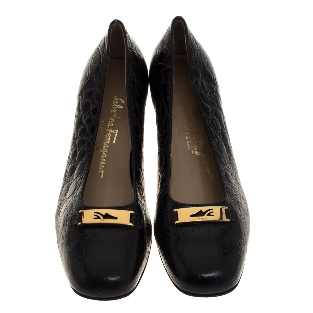 Salvatore Ferragamo präsentiert Ihnen diese umwerfenden Pumps aus Leder mit Kroko-Prägung für einen außergewöhnlichen Look. Diese schwarzfarbenen Pumps mit quadratischer Zehenpartie haben gravierte goldfarbene Akzente auf dem Obermaterial und einen