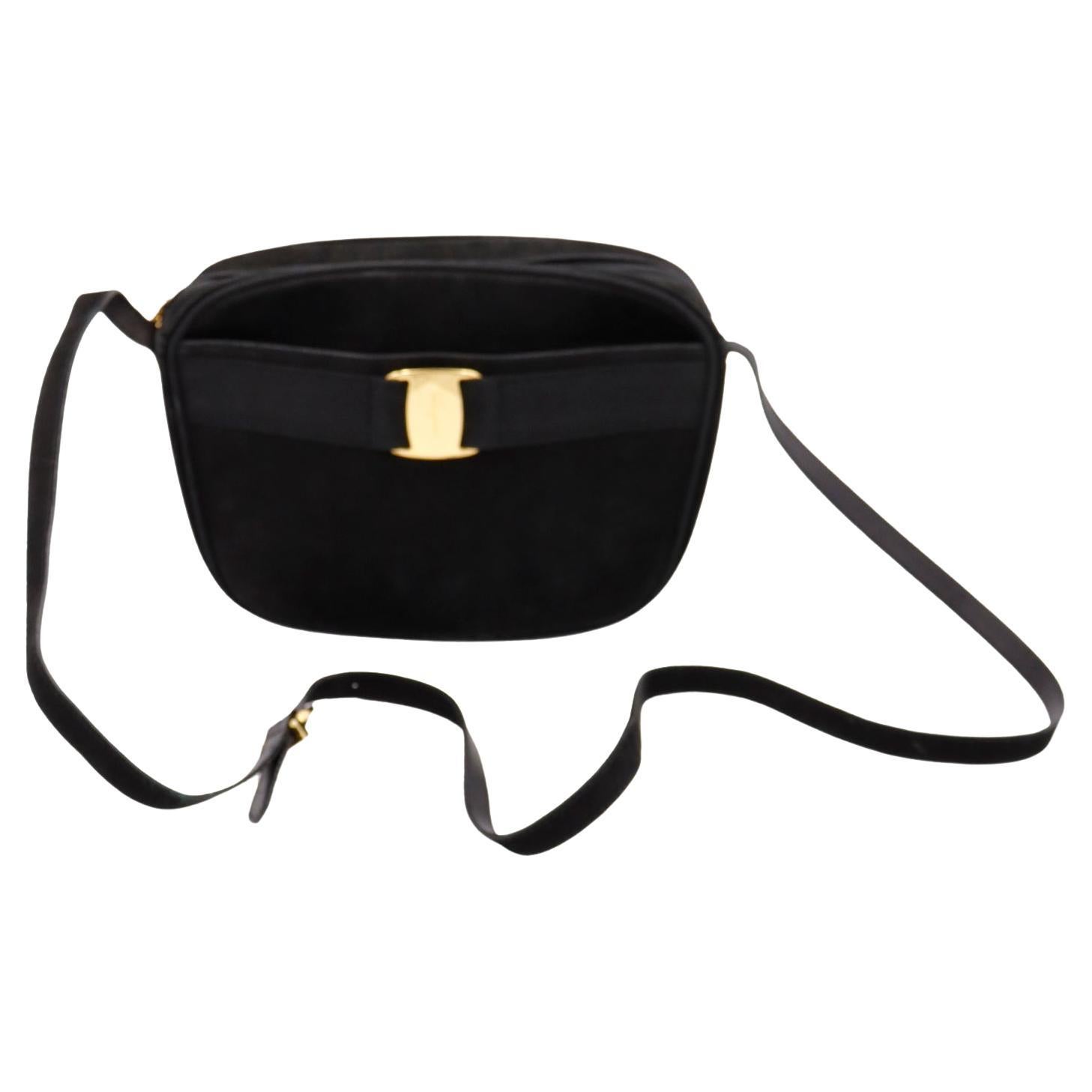 This timeless vintage Ferragamo suede shoulder bag is in a features engraved gold hardware that contrasts beautifully with the rich black suede. This bag has grosgrain ribbon detail on front that laces through the monogrammed Ferragamo gold buckle.