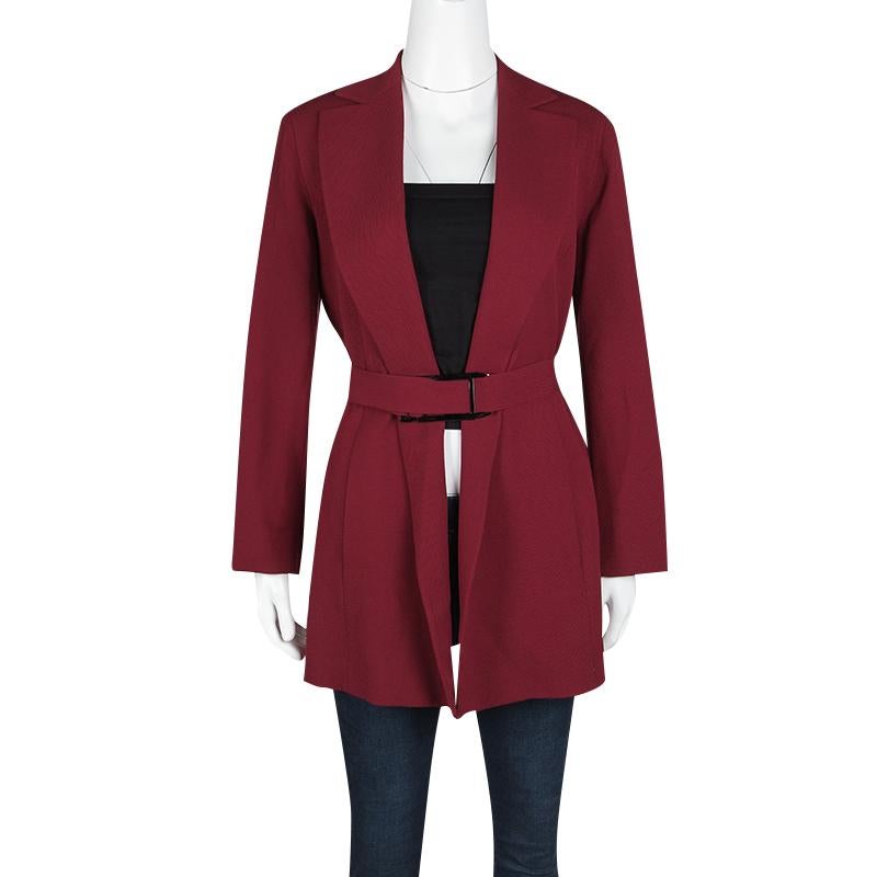 Add a dose of personality to your looks with this elegant Vintage coat from the house of Salvatore Ferragamo. It is crafted in a plush red fabric with wide lapels and comes with a tonal waistbelt secured with a metallic buckle. Team it independent