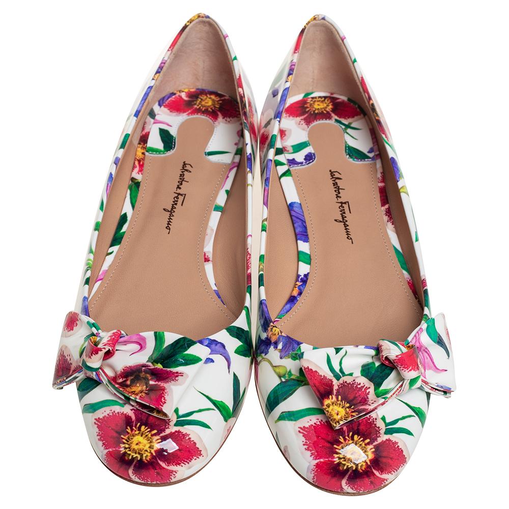 Ballet flats are for days of fun and frolic. These by Salvatore Ferragamo are crafted from patent leather and detailed with floral prints and bows. The insoles are leather-lined for steps of endless comfort.

Includes: Original Dustbag, Original