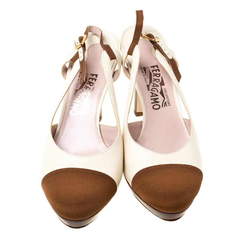 Combining the contrasting shades of white and brown, this pair of Salvatore Ferragamo pumps will add some charm to your look. Their canvas round toes are coupled with platforms and 10cm heels. The white leather pair features an adjustable sling-back