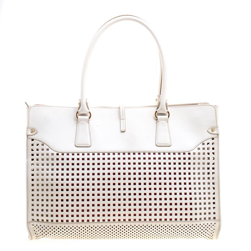 Wonderfully crafted from leather, this white Salvatore Ferragamo tote comes with a spacious interior. The bag is designed with perforated detailing and equipped with two handles and gold-tone hardware. Swing this beauty wherever you go to lend your