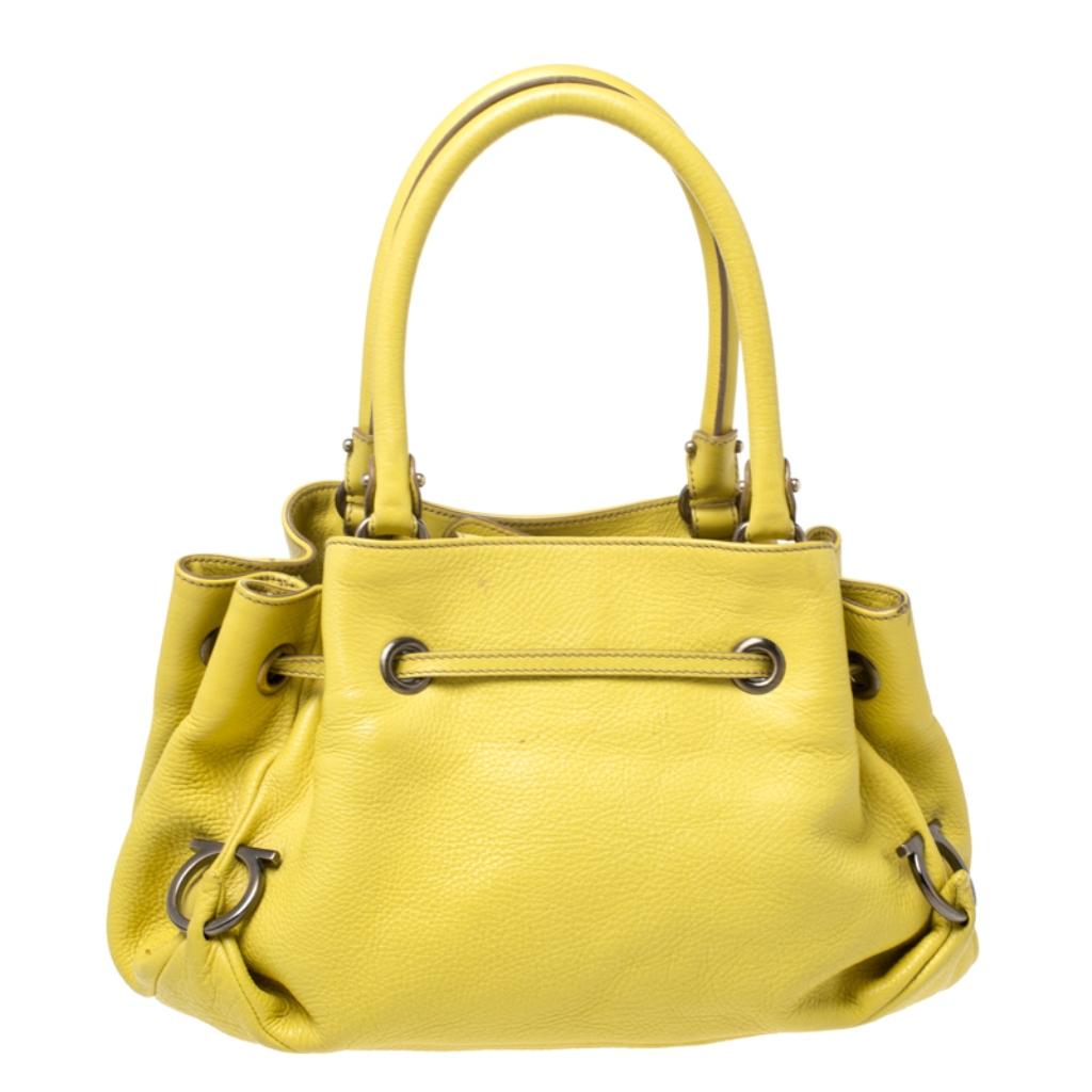 Upgrade your look with this Salvatore Ferragamo satchel instantly. It is crafted from yellow leather and features the iconic brand details on the exterior. The satin lined interior is spacious and the satchel flaunts dual handles.

Includes: