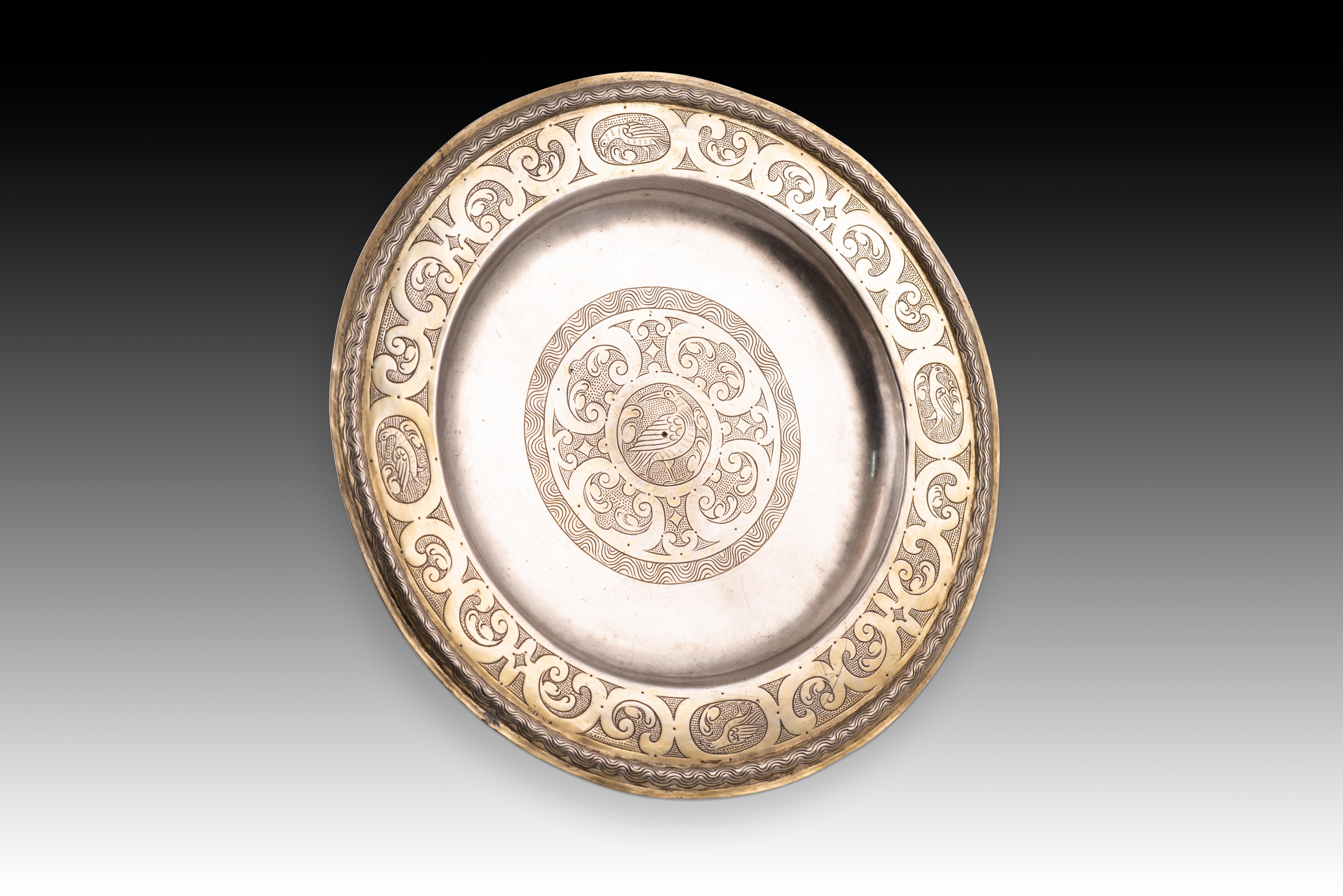 Salve or salve with a base. Silver. Zaragoza, 17th century. 
With contrast and engraving marks. 
Circular plate with a raised rim decorated with four ovals containing birds, alternating with reclining C-shapes (with vegetal motifs inside) in