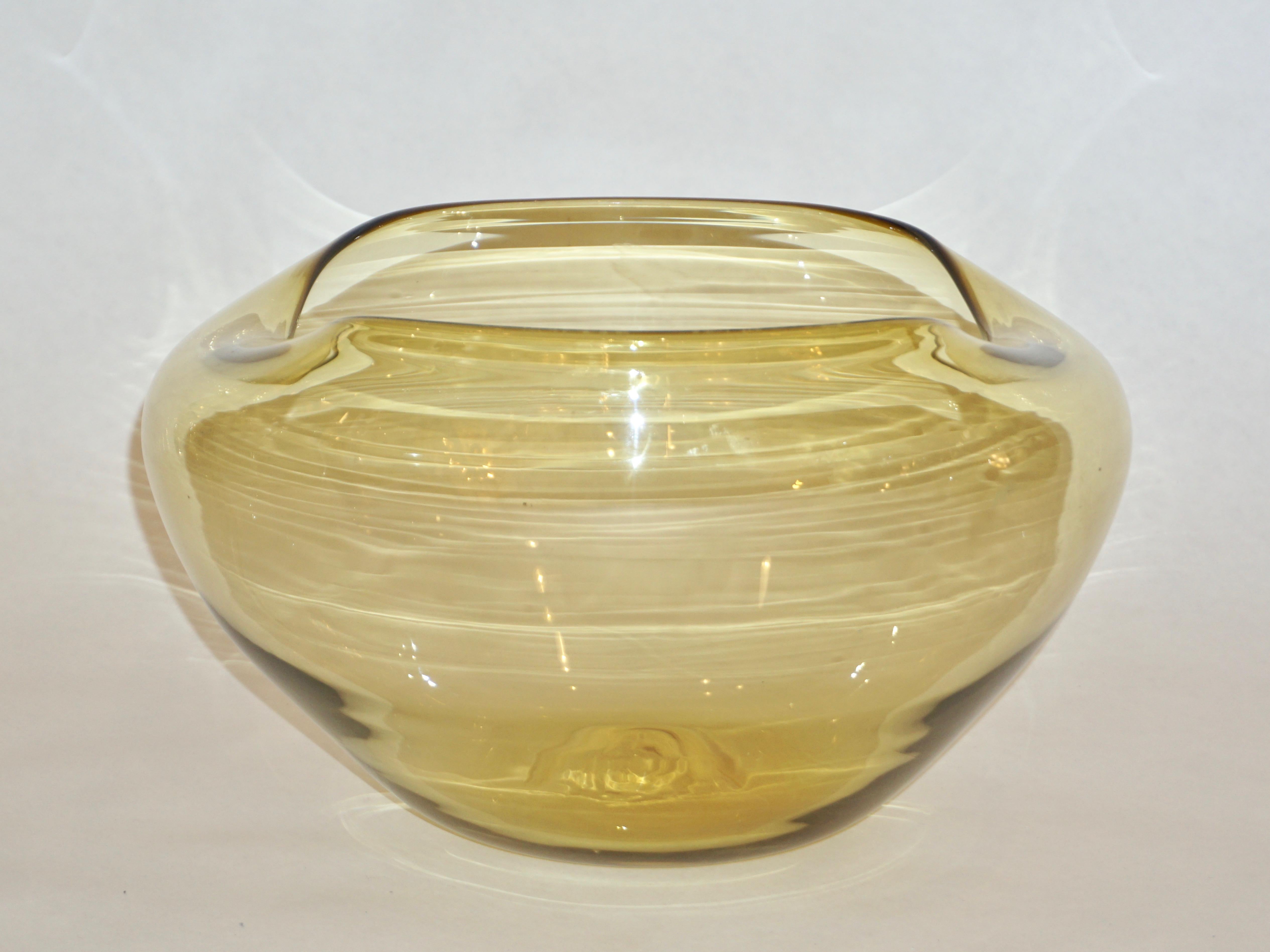 A minimalist yet sophisticated blown Murano glass vessel by Salviati, with signature, in warm honey amber color of organic modern design, waved border creating an inspiring abstract shape.
Can be accompanied by 2 other bowls as per photograph.