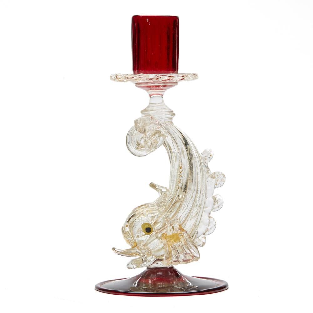 A fine stylish vintage Italian, Murano ruby glass candlestick with a dolphin stem attributed to Salviati and probably dating between 1930 and 1950. The hand blown candlestick has a rounded ruby red glass foot with a large hollow blown leaping