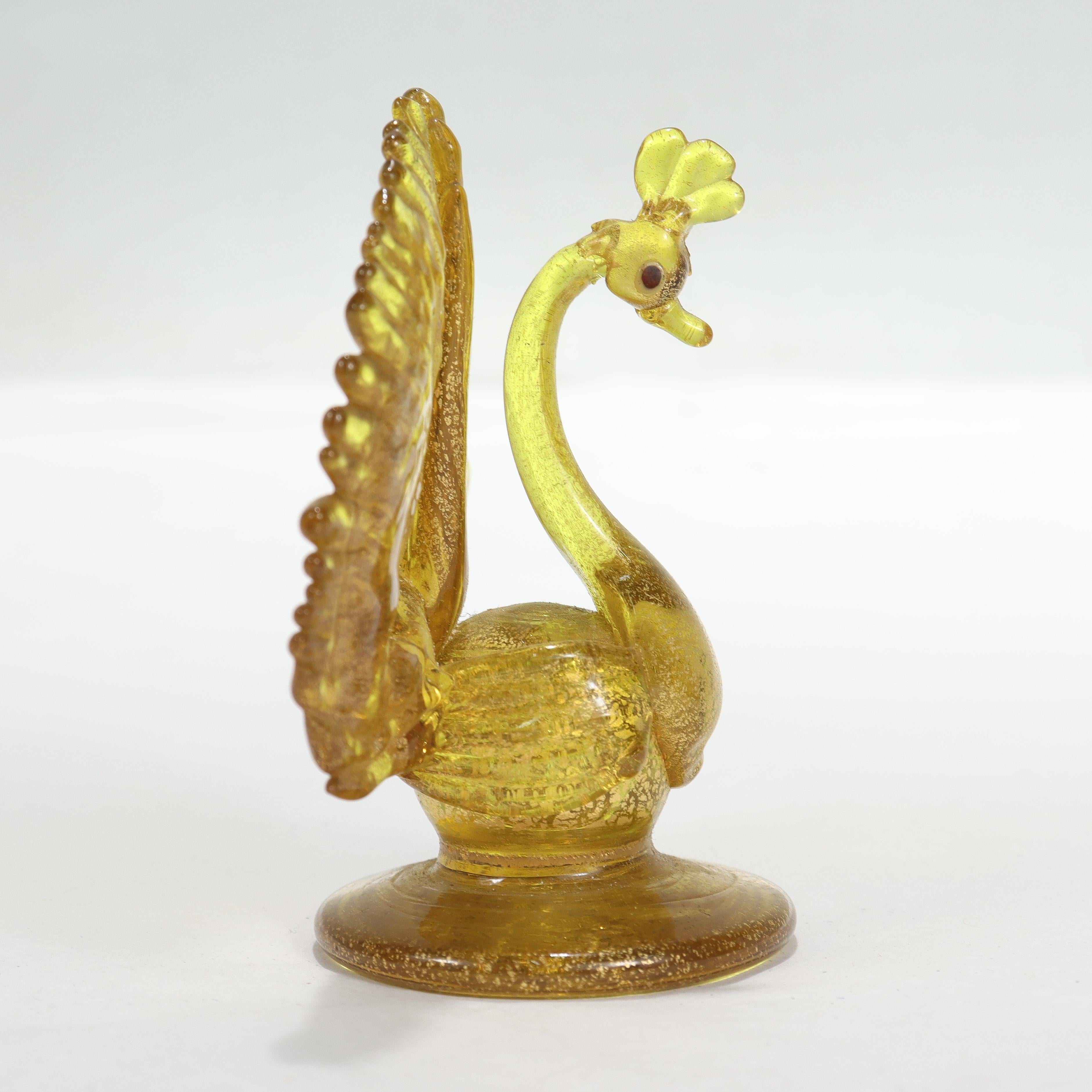 A fine vintage Venetian or Murano glass figurine or place card holder.

In the form of a peacock in yellow glass with gold foil with dark blue eyes.

Attributed to Salviati.

Simply a wonderful Venetian or Murano glass