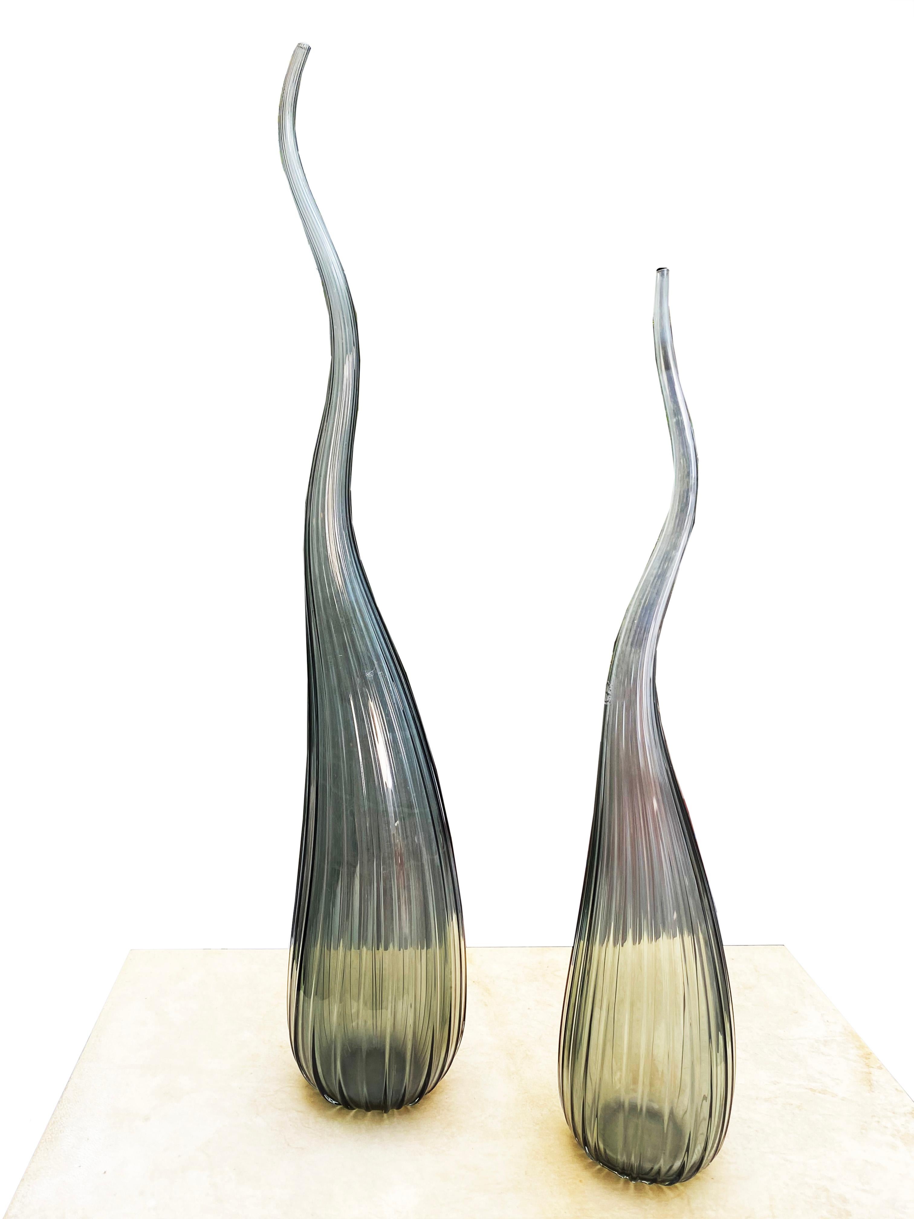 Salviati Murano
von Renzo Stellon
Modell Aria
2 Soliflores Vasen Modell Aria
aus rauchgrauem Muranoglas
piriforme Form mit langem, turbulentem Hals, der mit feinen Rippen verziert ist
unterzeichnet und datiert 2009
1 von 55 cm hoch
1 von 62