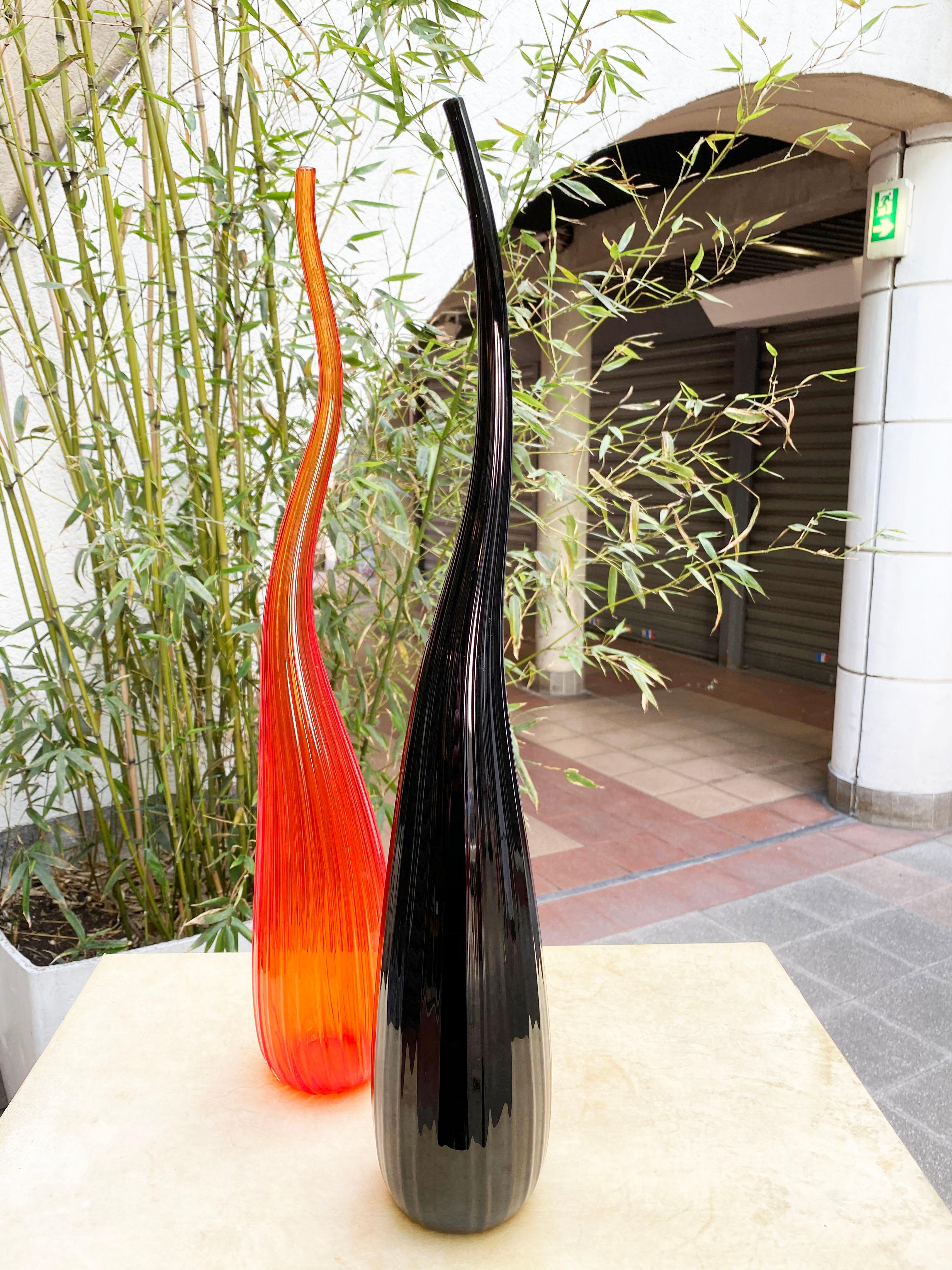 Salviati Murano
by Renzo Stellon
Aria model
2 soliflore vases model Aria
made of Murano glass
one in black Murano glass and one in orange Murano glass.
Piriform in shape with a long, turbulent neck decorated with fine ribs
signed and dated