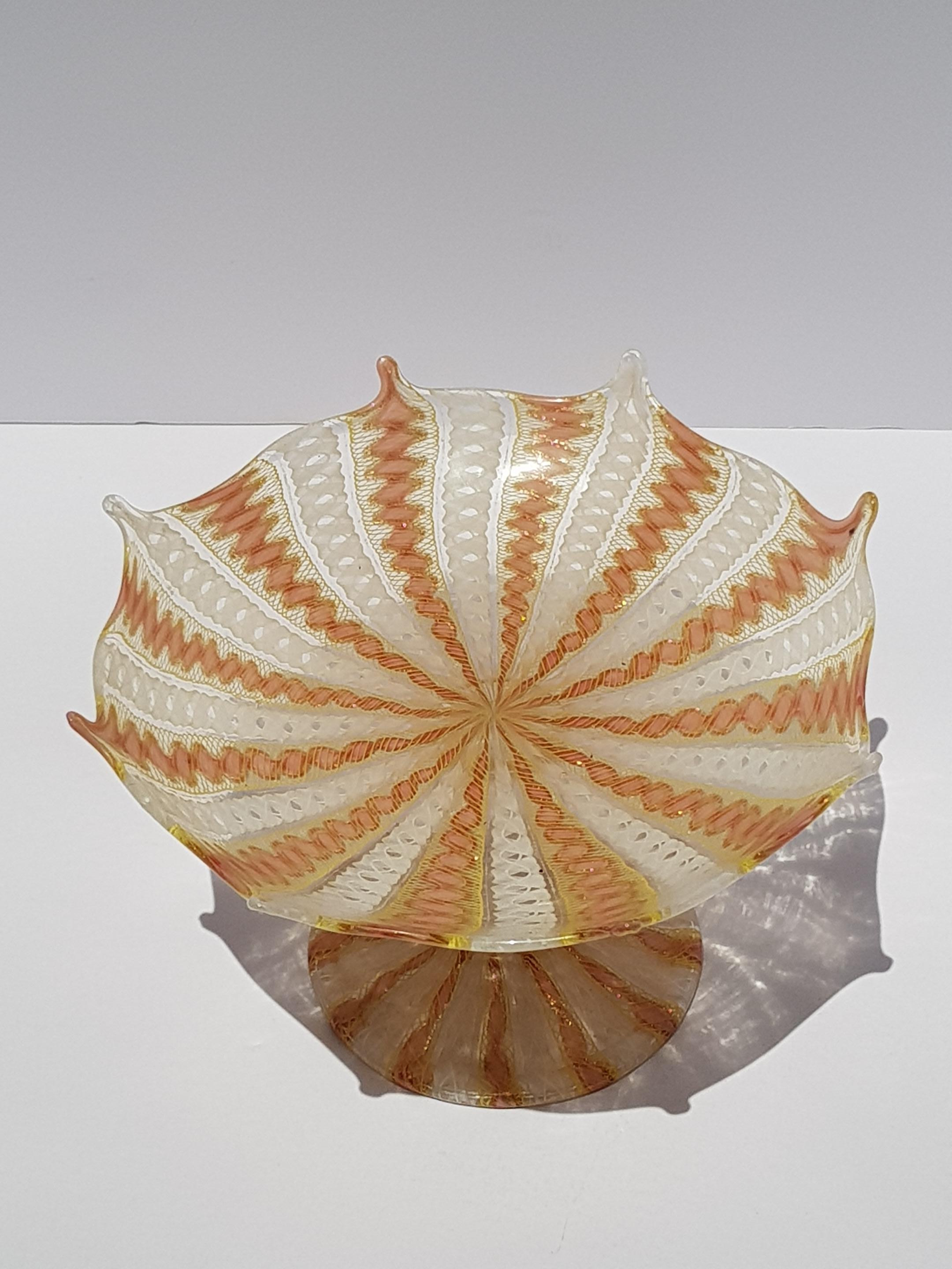 Questa squisita ciotola con piede in vetro di Murano Latticino Zanfirico di Salviati, realizzata intorno al 1880, è un superbo esempio della migliore arte vetraria veneziana del XIX secolo. Creato dall'iconica vetreria Salviati sull'isola veneziana