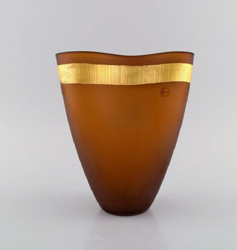 Salviati, Murano. Two vases in amber-coloured mouth-blown art glass with gold ribbon. Italian design. Early 21st century.
Measures: 21 x 18 cm.
In excellent condition.
Sticker.