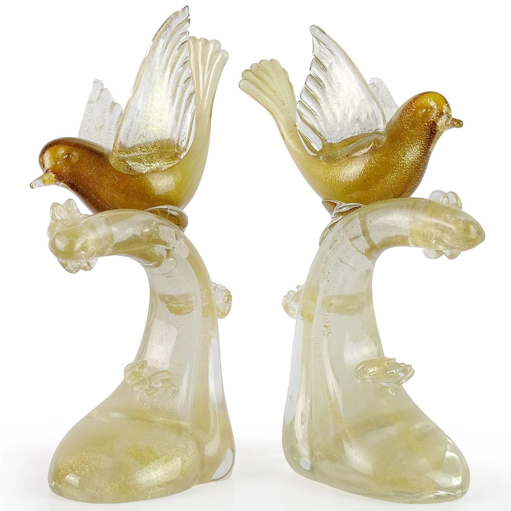 Gorgeous matched pair of vintage Murano hand blown white, dark amber and gold flecks Italian art glass bird on branch sculptures. Documented to the Salviati company, with worn original label underneath. The pieces are profusely covered in gold leaf,