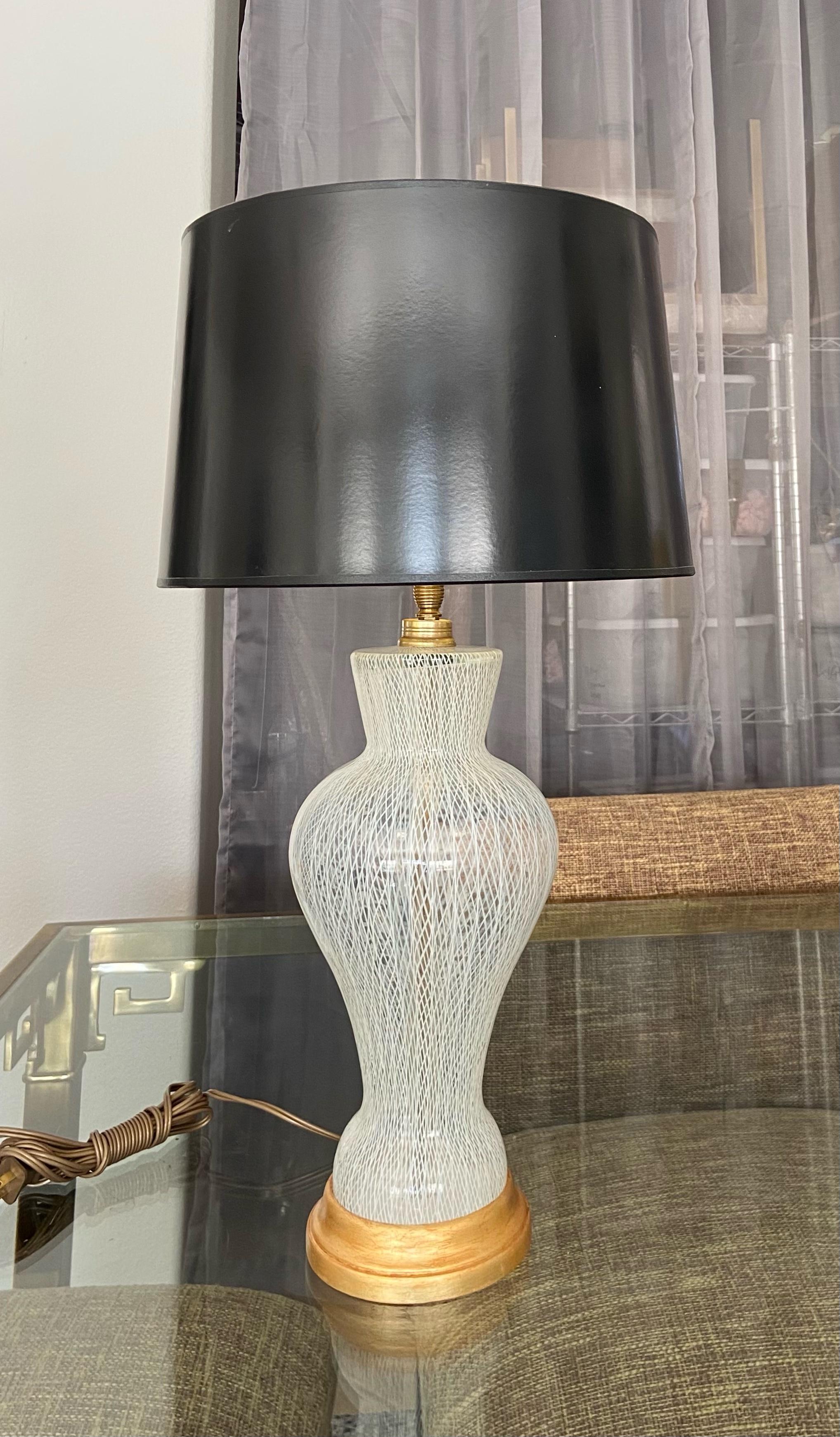 Lampe de table à motif latticino (dentelle blanche) en verre d'art vénitien de Murano, sur une base en bois doré avec des ferrures en laiton. Câblage refait à neuf avec une nouvelle prise à 3 voies en laiton et un nouveau cordon. Le verre soufflé à