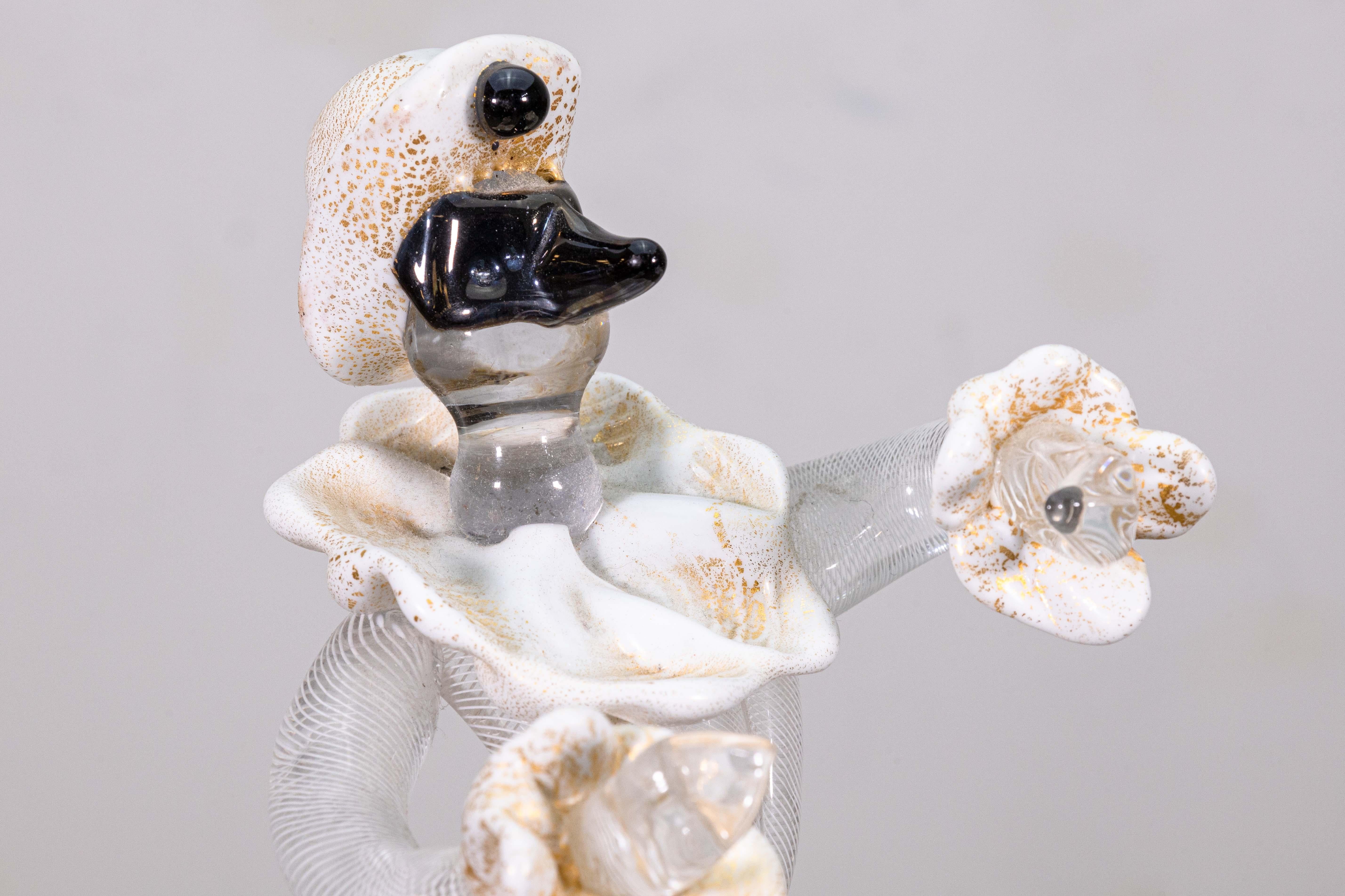 Una escultura de mesa Arlequín de cristal de Murano Salviati. Esta bonita escultura de mesa presenta un adorable bufón figurativo. El cristal de Murano soplado a mano de esta pieza es una increíble muestra de talento y creatividad. El cuerpo