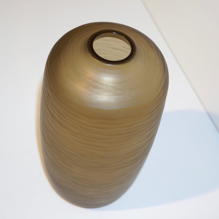 Late 1970s - Early 1980s Mid-Century Modern Venetian vase of elegant Minimalist ovoid shape, in a chic smoked amber gold Murano glass, blown by Salviati, with a high-quality decoration in a precious wavy battuto on the entire surface. Battuto means