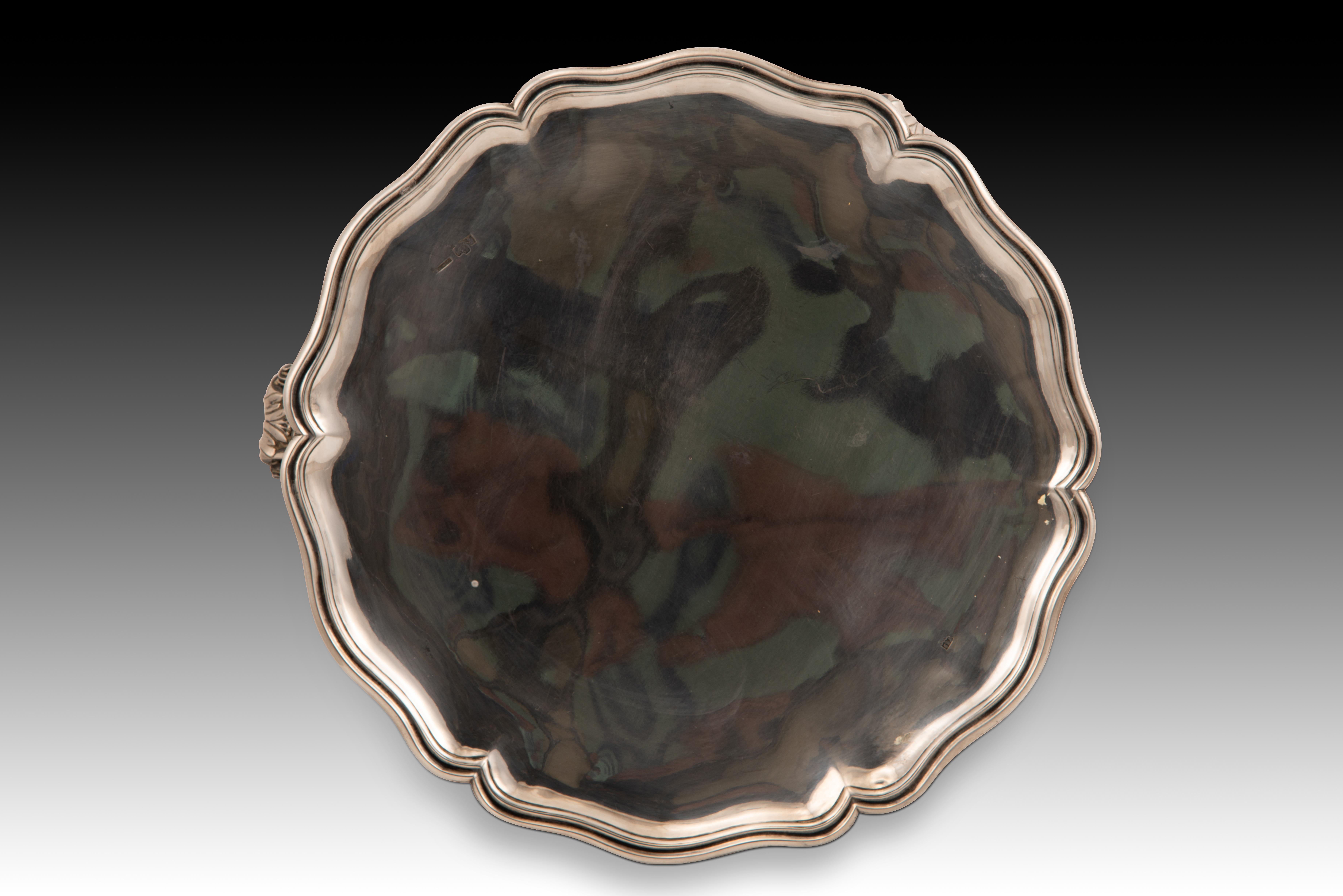 Salvilla. Silber. Santander, Spanien, Ende des 18. Jahrhunderts. 
 Mit Kontrastmarkierungen.
 Eine Servierplatte aus Silber in ihrer natürlichen Farbe, mit Beinen, die aus architektonischen Elementen in Kombination mit pflanzlichen Motiven bestehen