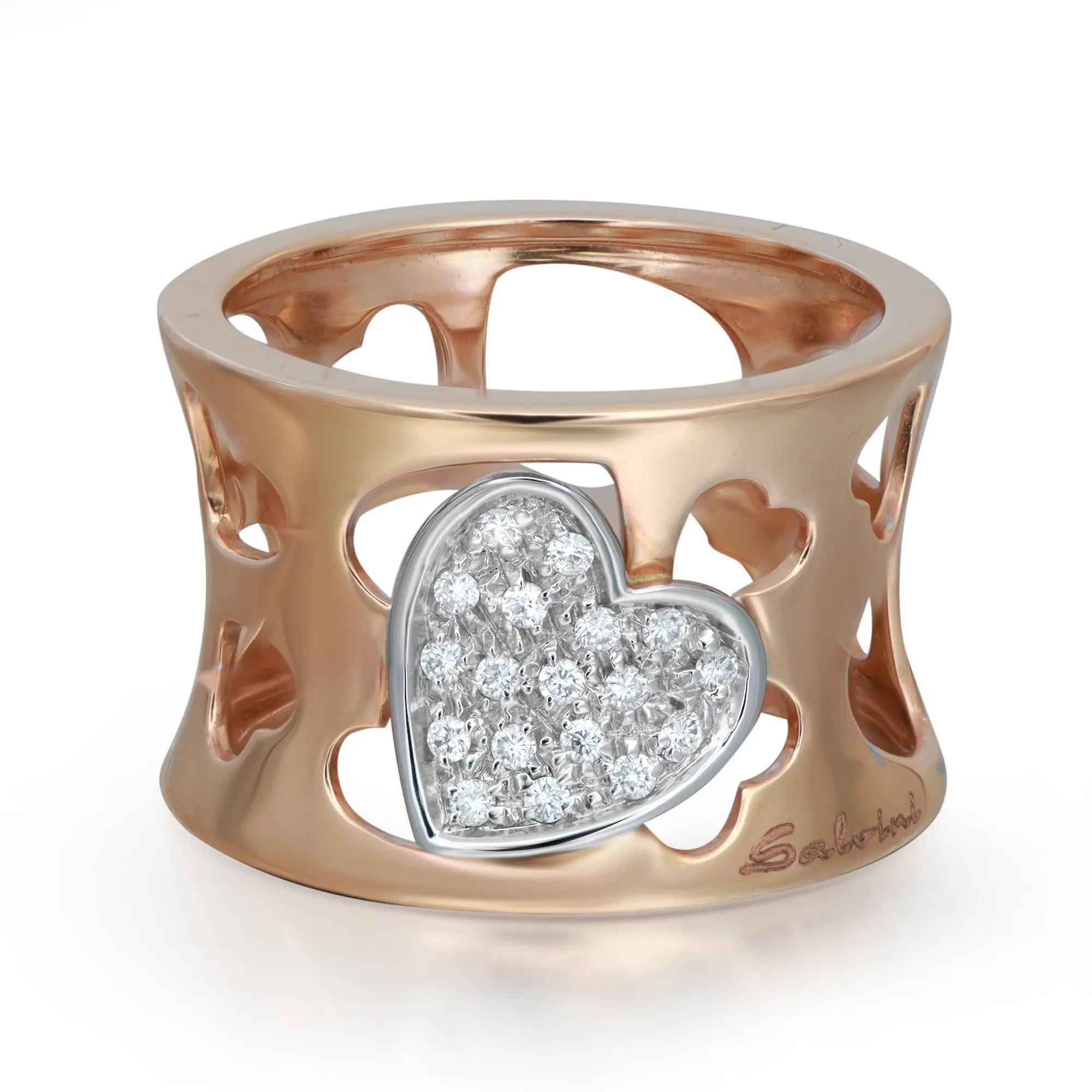 Modern ladies wide band ring crafted in 18k rose gold. This ring features hearts cut outs with round cut diamonds encrusted in one heart in white gold in pave setting. Total diamond weight: 0.14 carat. Ring size: 7. Ring width: 13.8mm. Total weight: