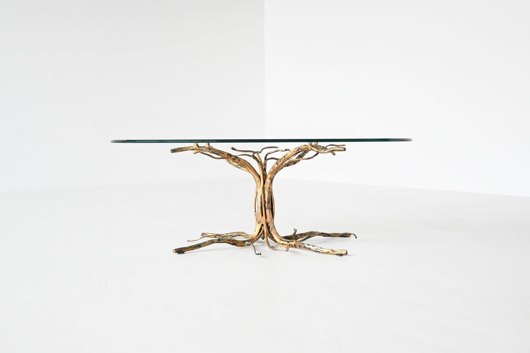 Amazing shaped brutalist coffee table designed and manufactured by sculptor Salvino Marsura, Italy 1970. This very nice handcrafted table shows a tree in heavy gilt wrought iron. This base supports an original thick oval glass top. Highly decorative