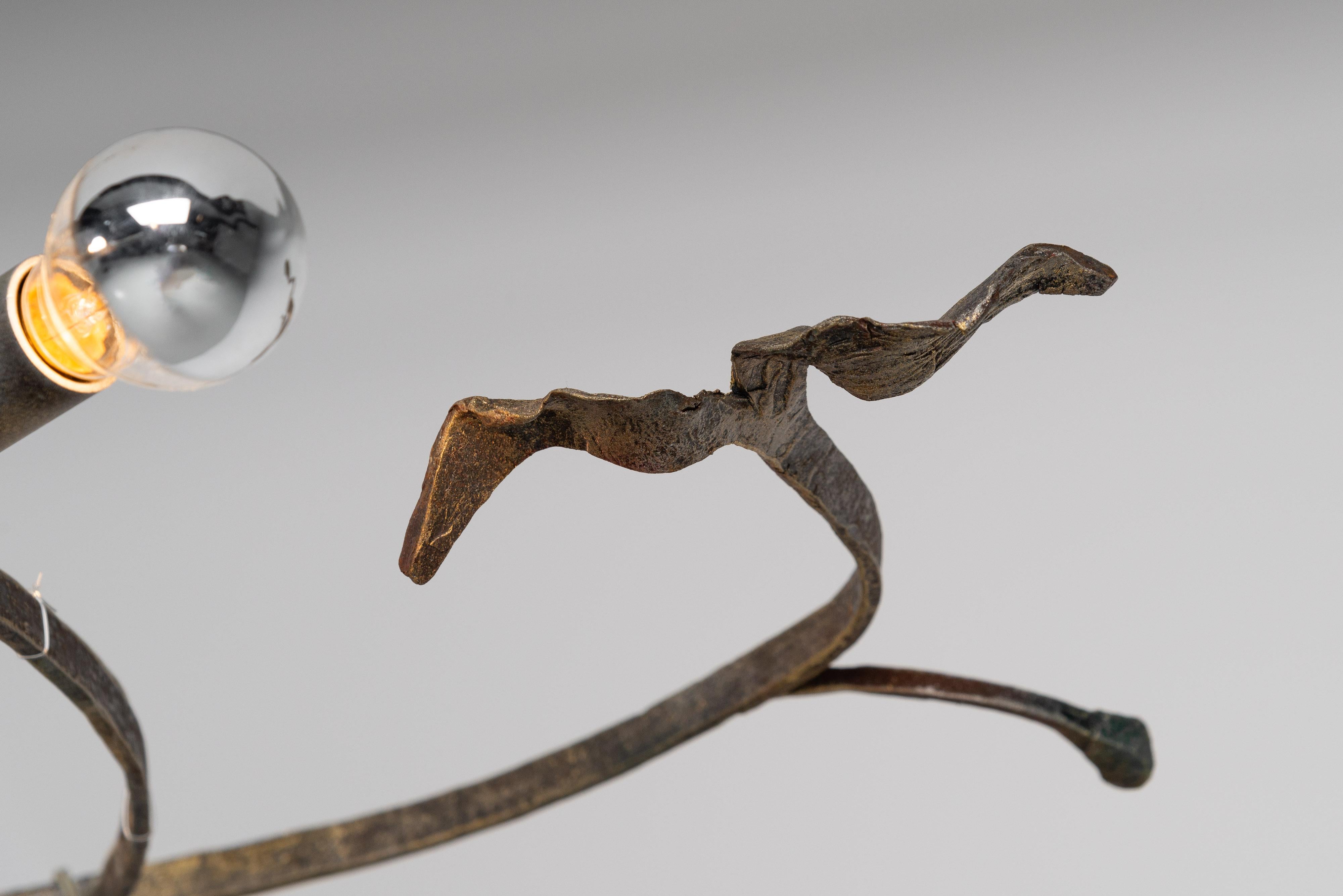This sculptural chandelier, is a unique piece designed by Salvino Marsura and crafted in his Italian atelier in 1970, is a stunning fusion of art and functionality. Made from meticulously hammered and welded wrought iron, it boasts a bold brutalist
