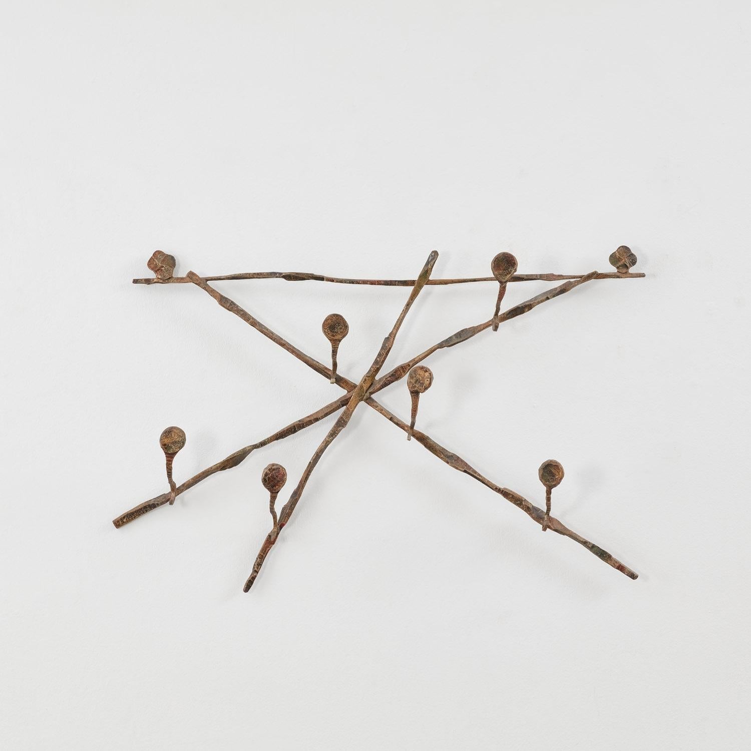 Les bourgeons ou les spores germent en crochets courbes suspendus à un treillis de formes X entrecroisées, à l'image de ce portemanteau en fer forgé. 

La pièce est en bon état, le fer présentant une patine fidèle à son âge.

Salvino Marsura