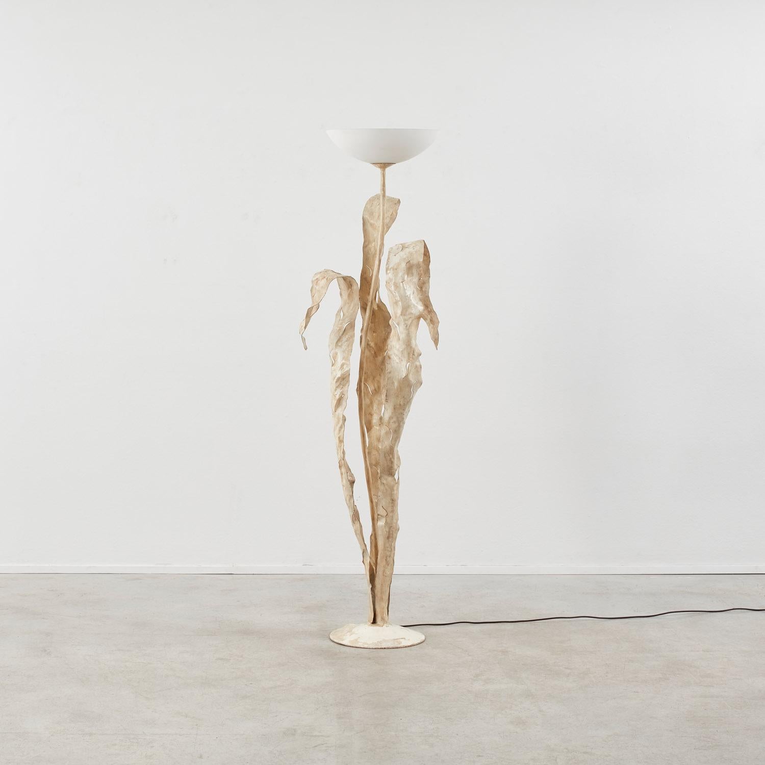 An Art Nouveau sensibility shapes the three leaves that curl and fold around the stem of the Fiore floor lamp, finished by a delicate hand-blown glass shade. 

The piece is in good condition. The iron varnish features patination true to its age,