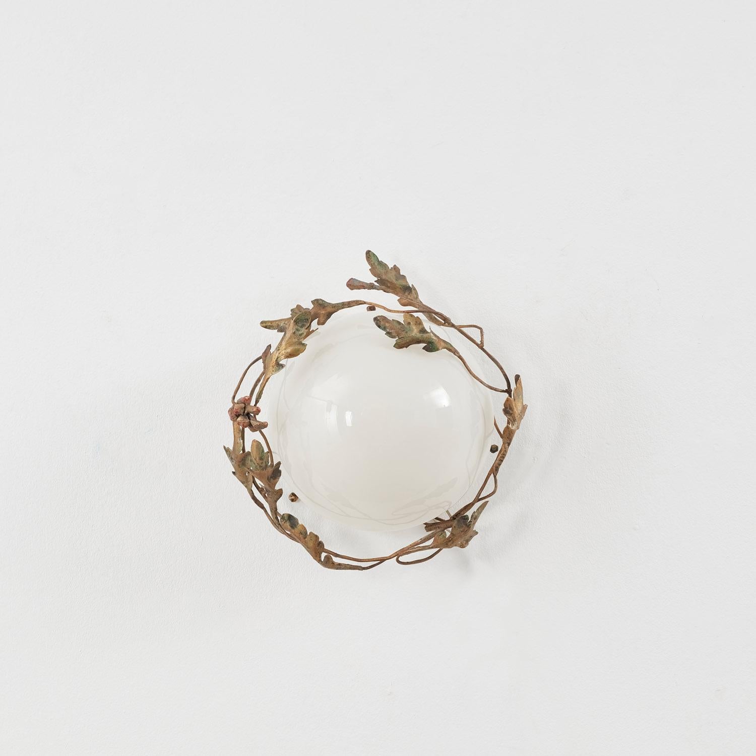 Des branches s'enroulent autour de cette applique lumineuse, où les feuilles et le pin s'enroulent dans un rythme coalescent. 

La pièce est en bon état, avec le verre d'origine. Il a été récemment recâblé et testé selon les normes britanniques.  