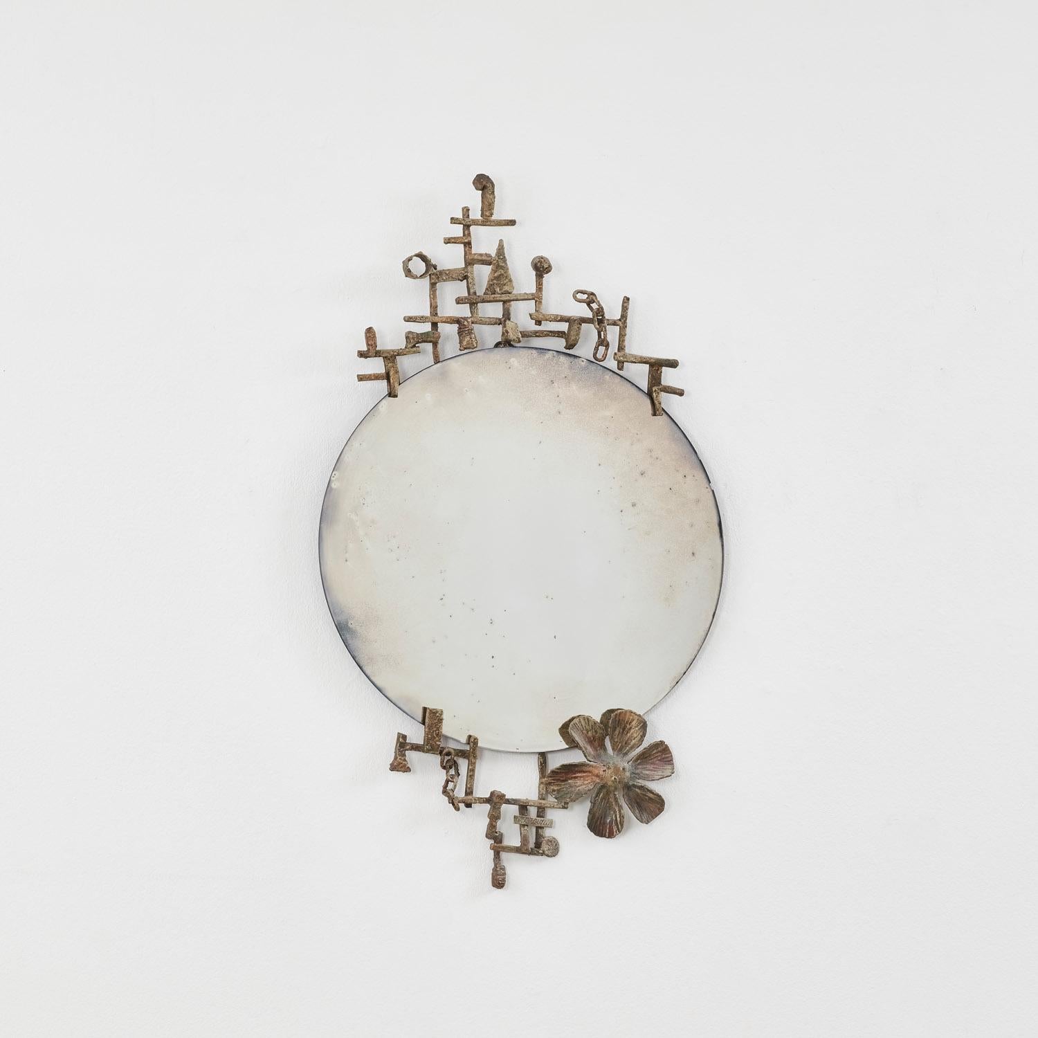 Des lignes de fer en treillis forment un cadre géométrique autour du Miroir forgé I. À l'intérieur de cette grille, des formes et des motifs se rassemblent : une fleur, des chaînes, des triangles et des cercles, ce qui en fait l'une des œuvres les