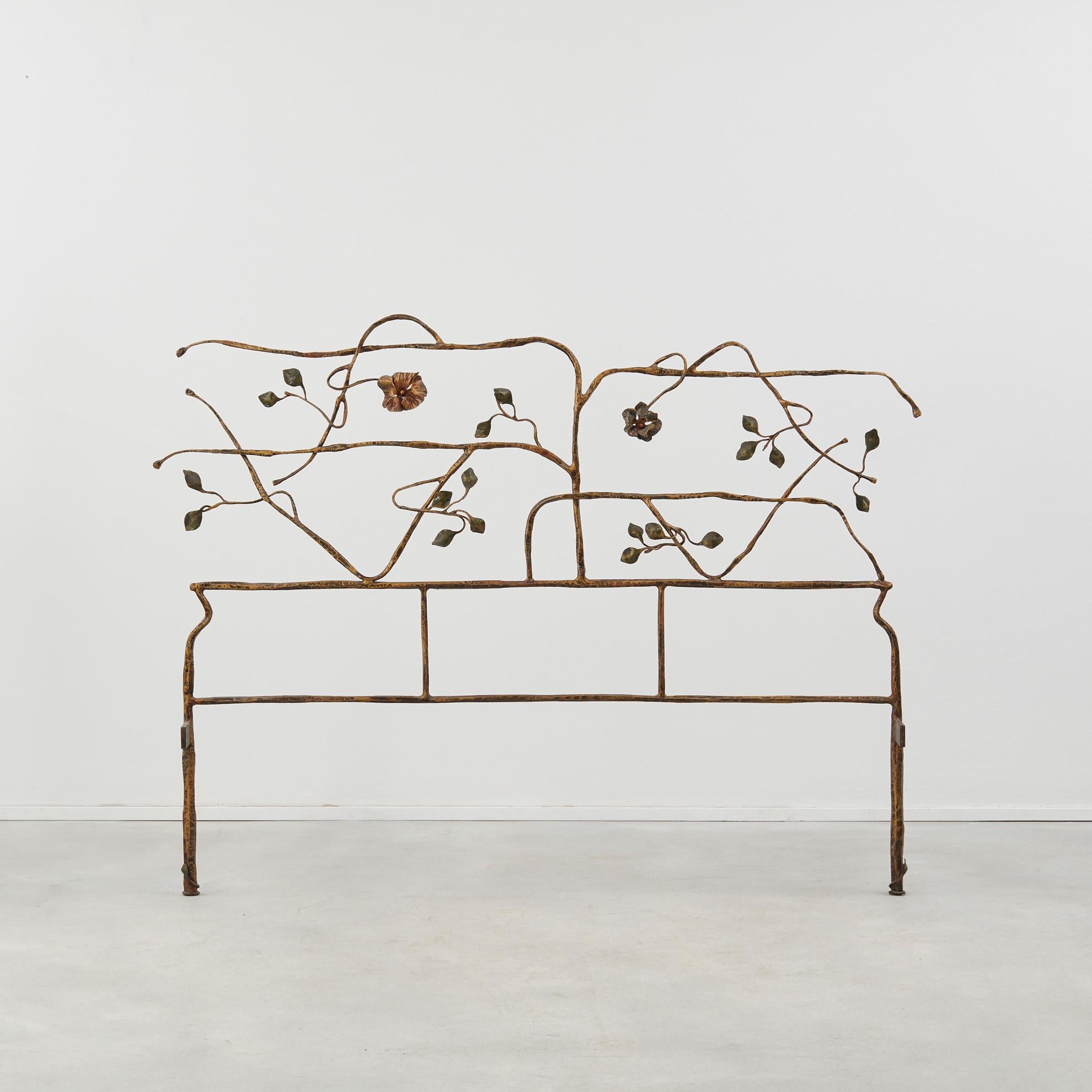 Des branches latérales en fer forgé poussent organiquement sur cette tête de lit. Sobre mais poétique, cette tête de lit de jardin est parsemée de roses et de brins de feuilles. 

La pièce est en bon état et présente une patine fidèle à son