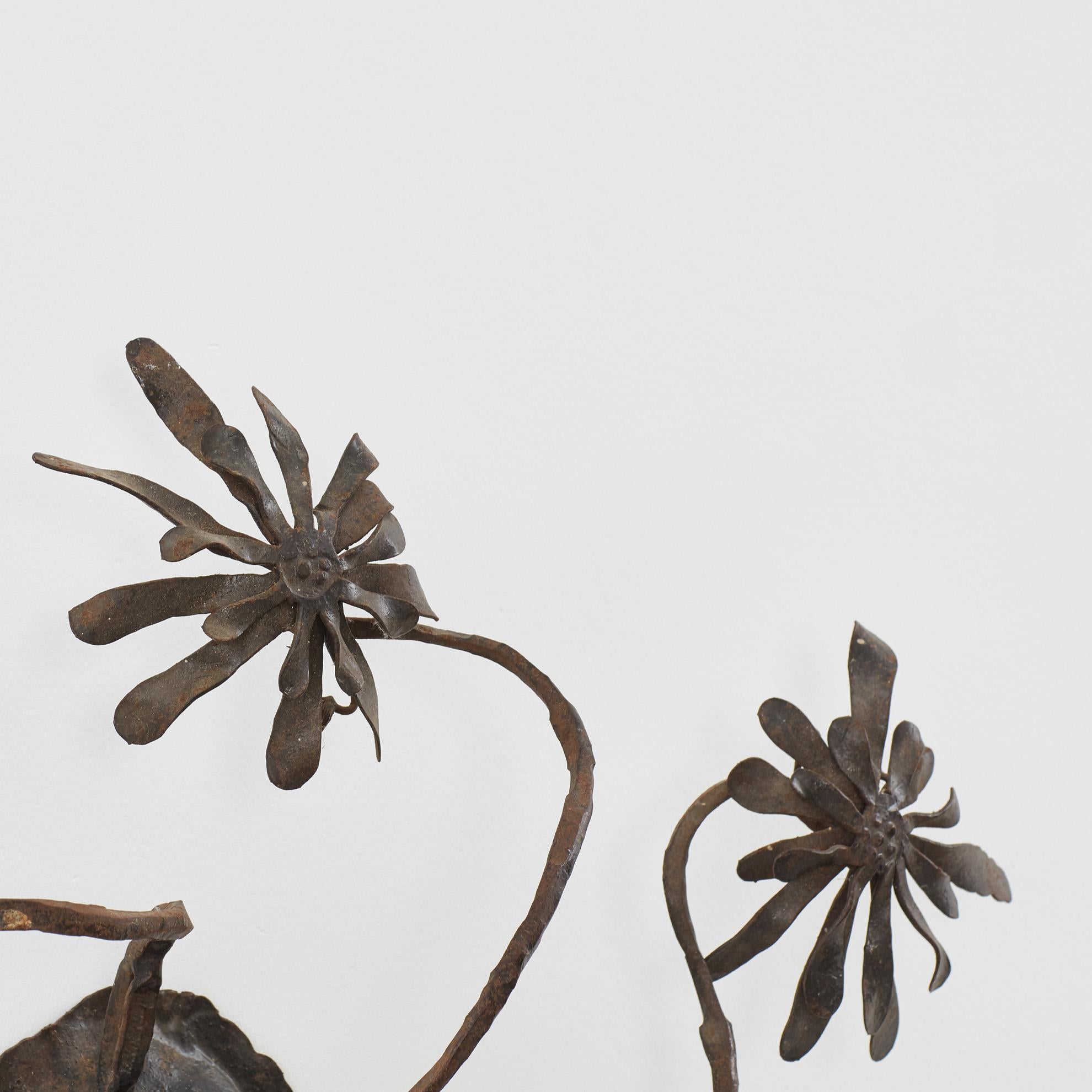 Cinq marguerites en fer, chacune avec des pétales ouvragés, entourent les ampoules de l'applique Margherite. Ses tiges élancées projettent des ombres douces sur le mur et se rejoignent au centre pour compléter la pièce. 

La pièce est en bon état et