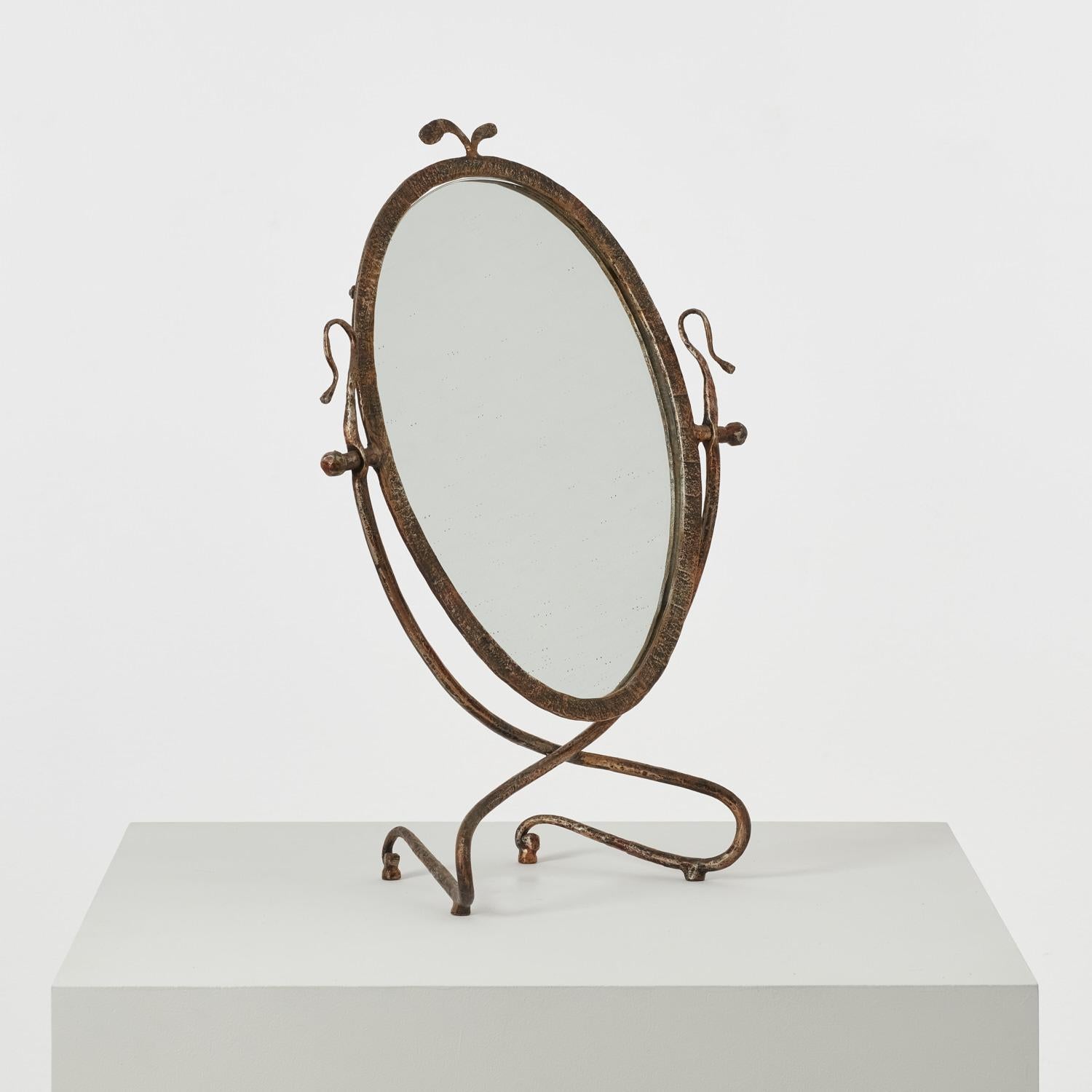 La Specchiera da tavolo, ou miroir de table, se définit par ses deux lignes sinueuses. Suspendues de part et d'autre du miroir, les lignes commencent par s'épanouir avant de s'enfoncer dans une embardée, se croisant à la base du miroir avant de
