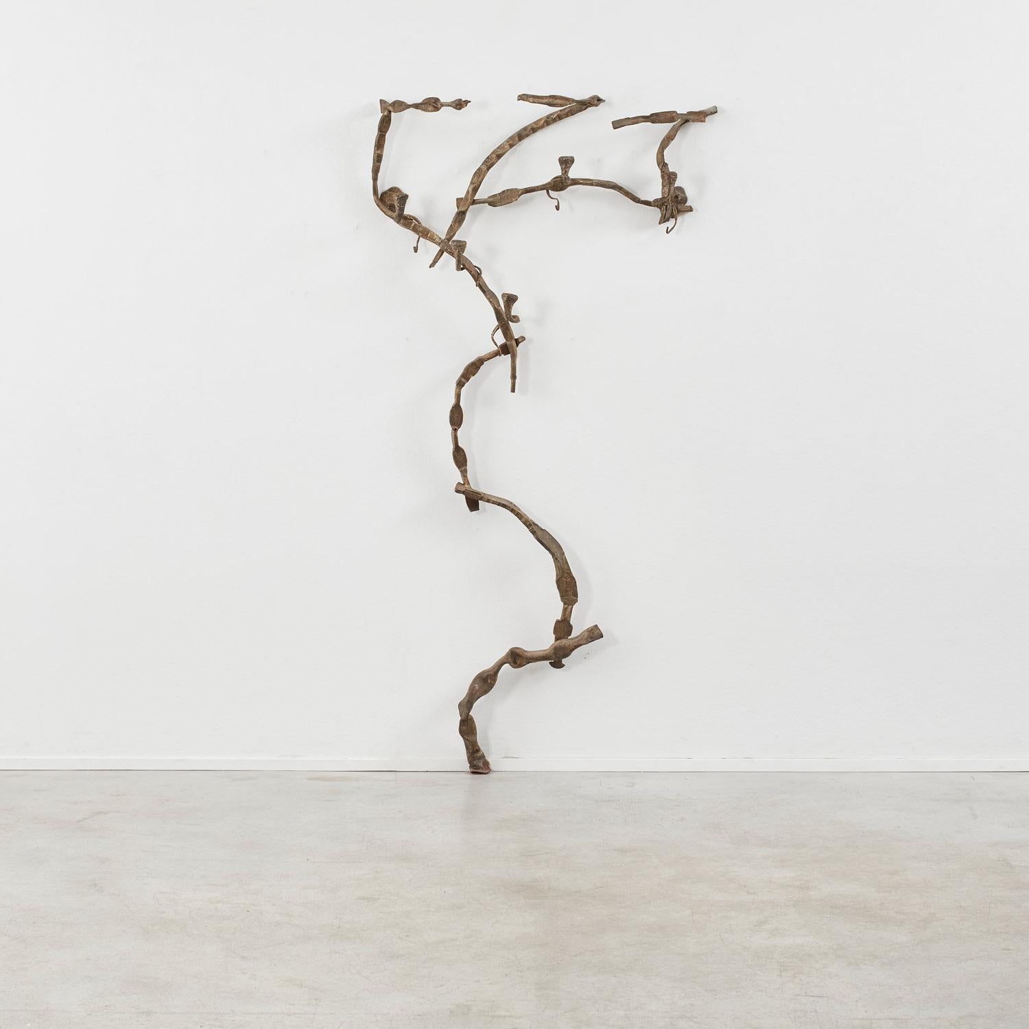 Shoots of growth, like branches, move in unrestrained, asymmetric ways across this sculptural coat rack. Growing upward across the wall, the piece is completed with buds that coil and tendril, becoming hooks. 

The piece is in good condition,