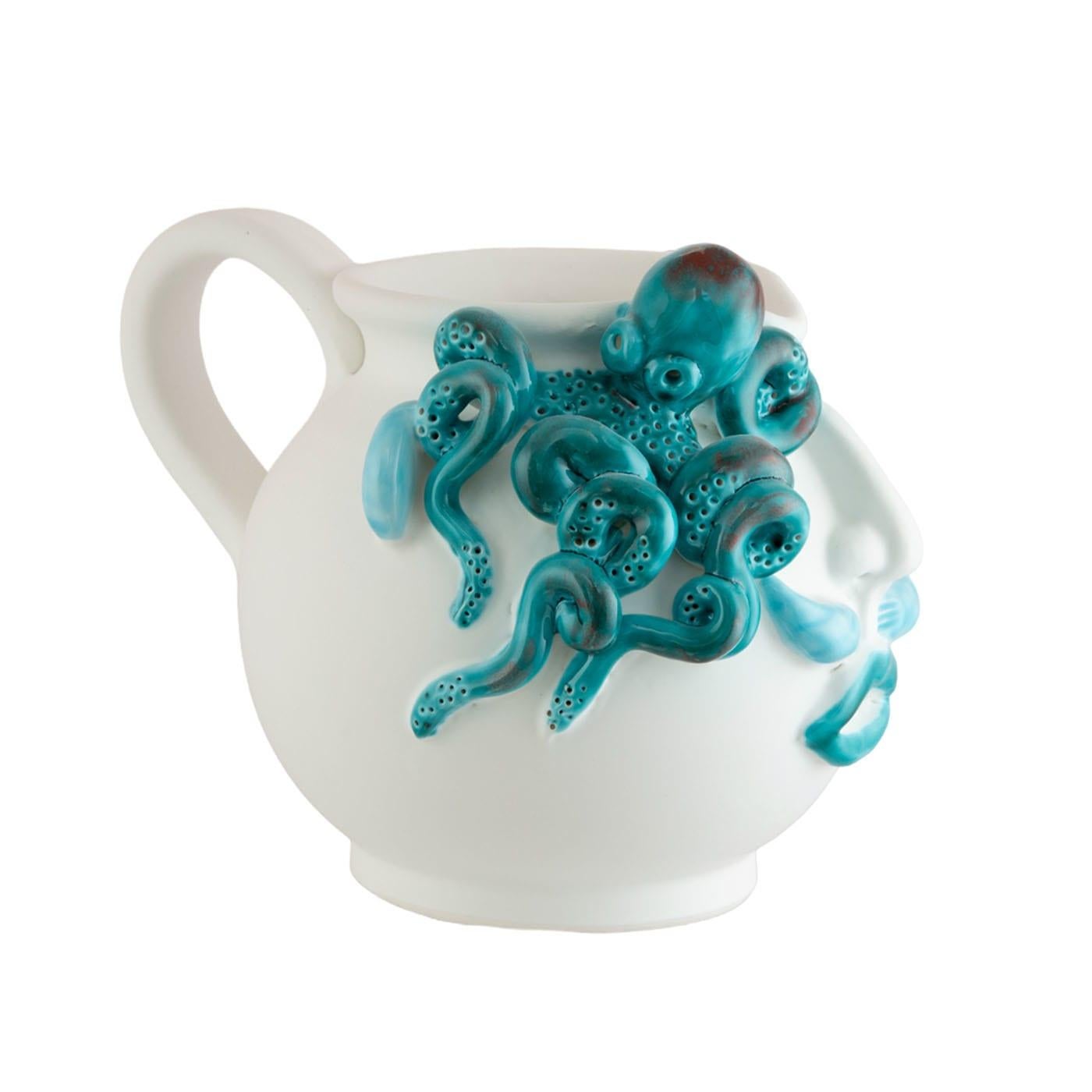 The large jug, adorned with a captivating face and an octopus motif, is meticulously crafted from white clay, finished with a smooth matte white glaze, and accentuated by vibrant blue, green, and red-colored crystals. This figurative masterpiece