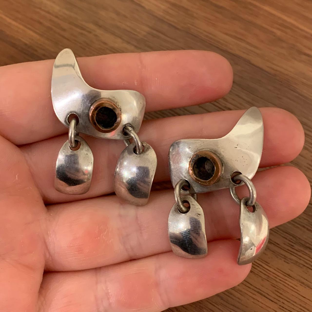 A pair of copper and sterling silver ear clips, by Sam Kramer, United States. Stamped with maker's mark, sterling. Numbered *****6. 

The earrings measure 1.55