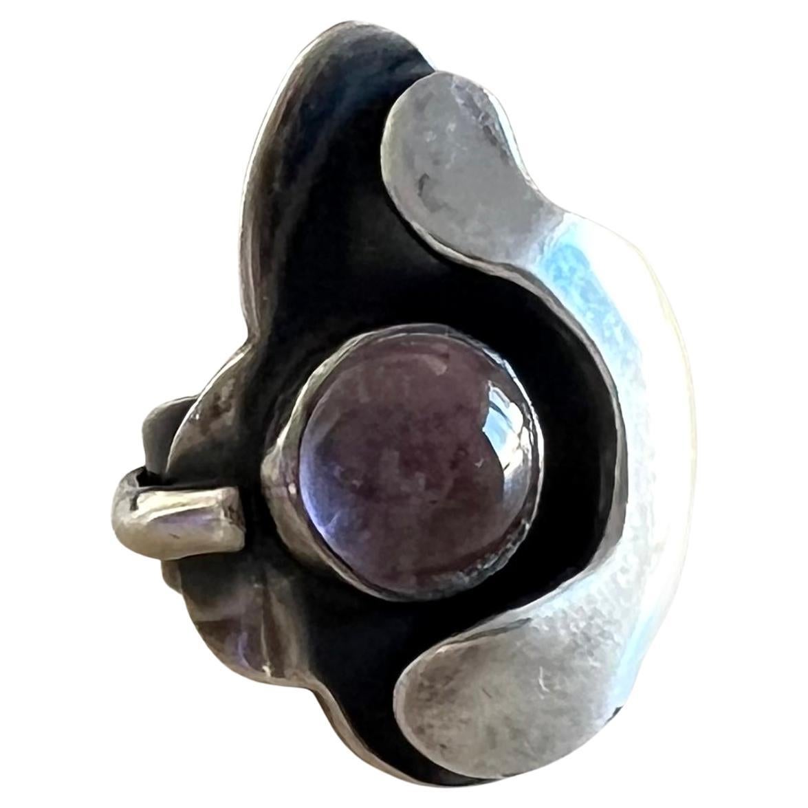Handmade double layered sterling silver amethyst cabochon ring created by Sam Kramer of New York, New York, circa 1950's. Rings face measures 1.5