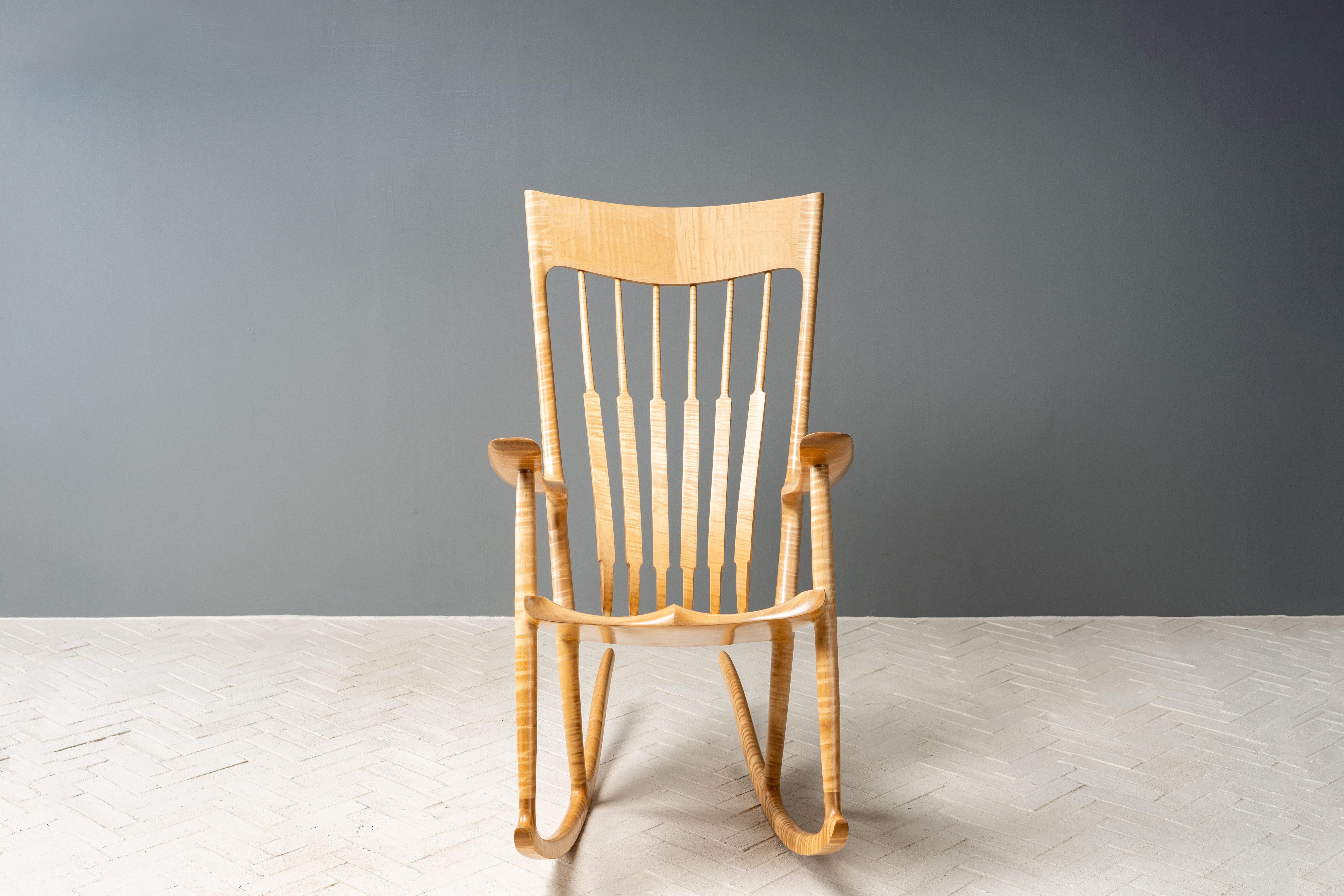 EEUU, hacia la década de 2000. Una impresionante y escultural mecedora del carpintero y fabricante de muebles de estudio estadounidense Sam Maloof (1916-2009). Presenta una increíble construcción de arce fiddleback con líneas arrolladoras que acunan