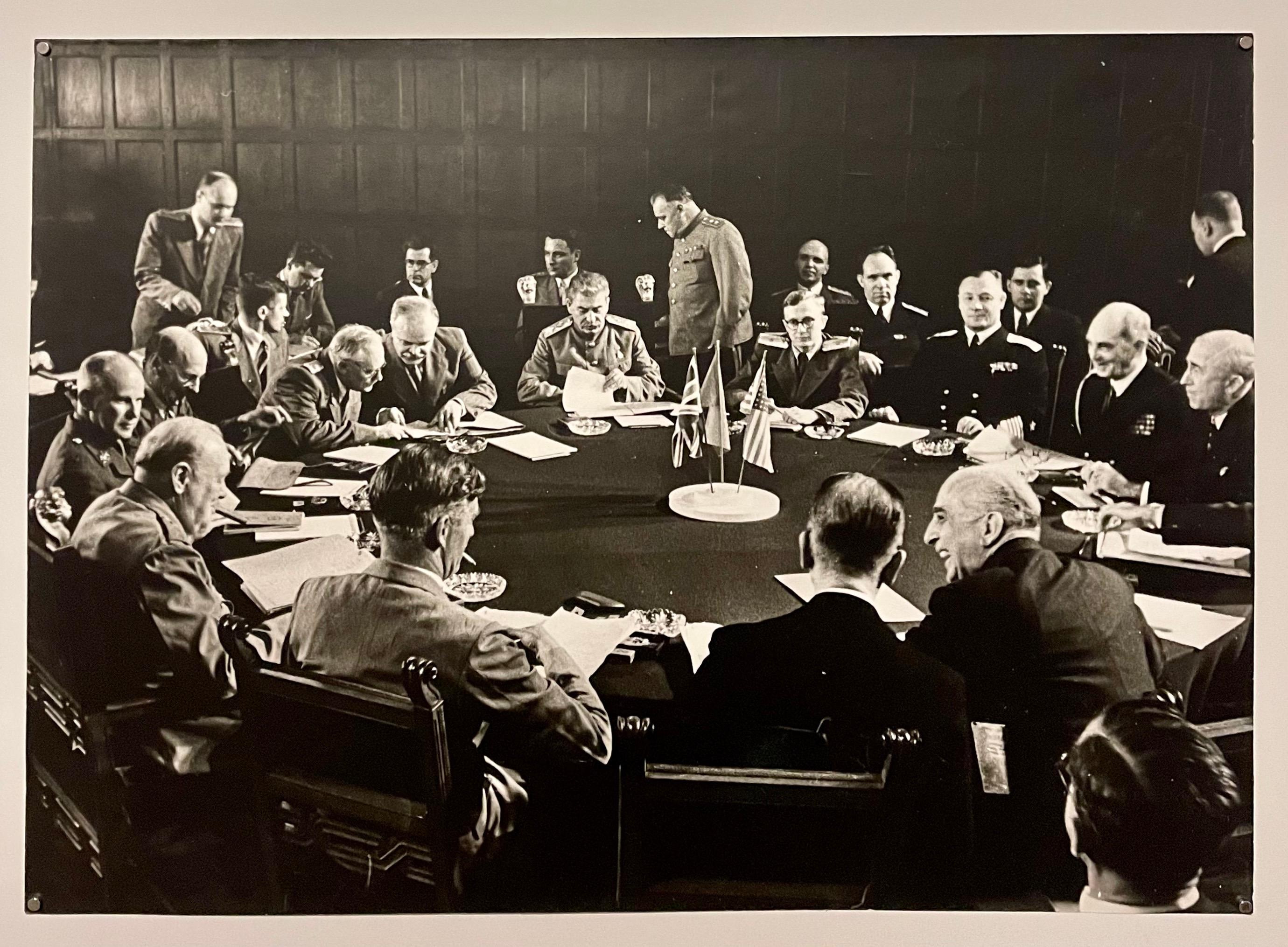 Potsdam conference meeting depicting Josef Stalin, Winston Churchill and Harry Truman (not visible) at the conference table, gelatin silver print, date of printing unknown, 
16-1/2