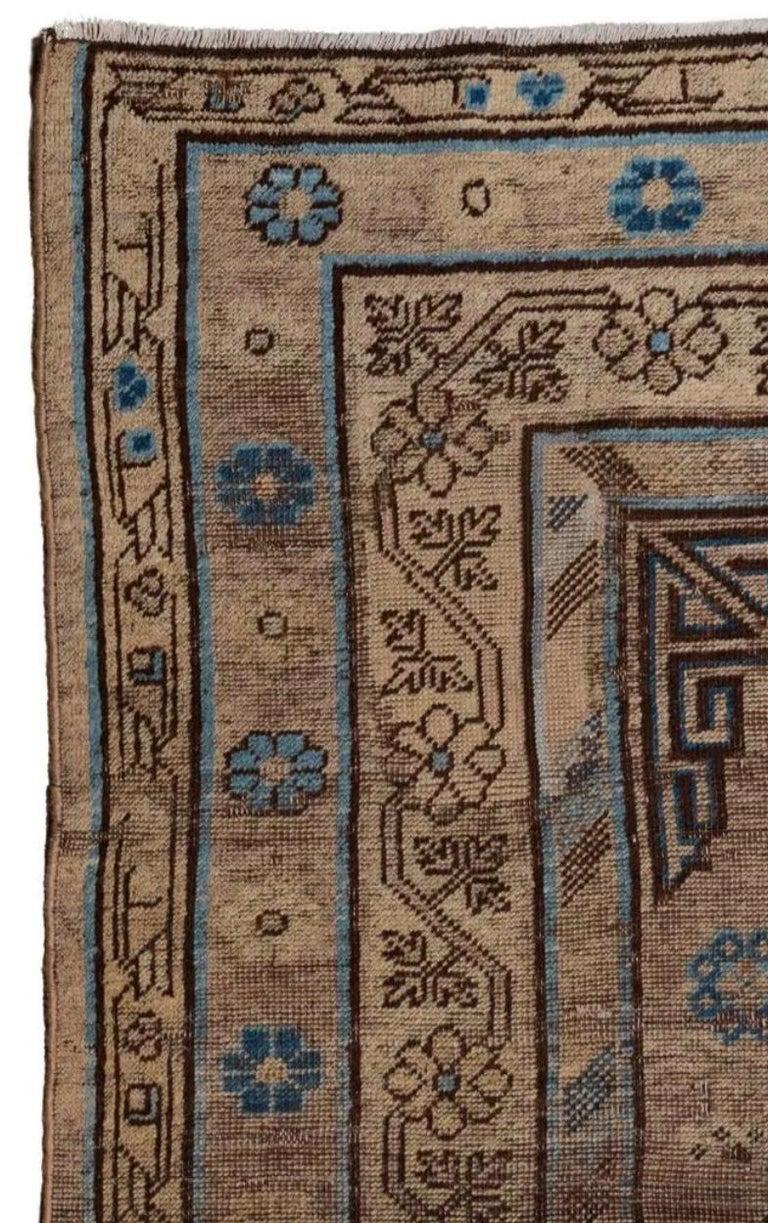 Dieses Khotan aus den 1920er Jahren zeigt ein geometrisches Medaillon, das von zwei kreisförmigen Medaillons flankiert wird, sowie weitere Khotan-Elemente aus dem 18. und Samarkand aus dem 19. Dieser Teppich passt sowohl zu traditionellen als auch
