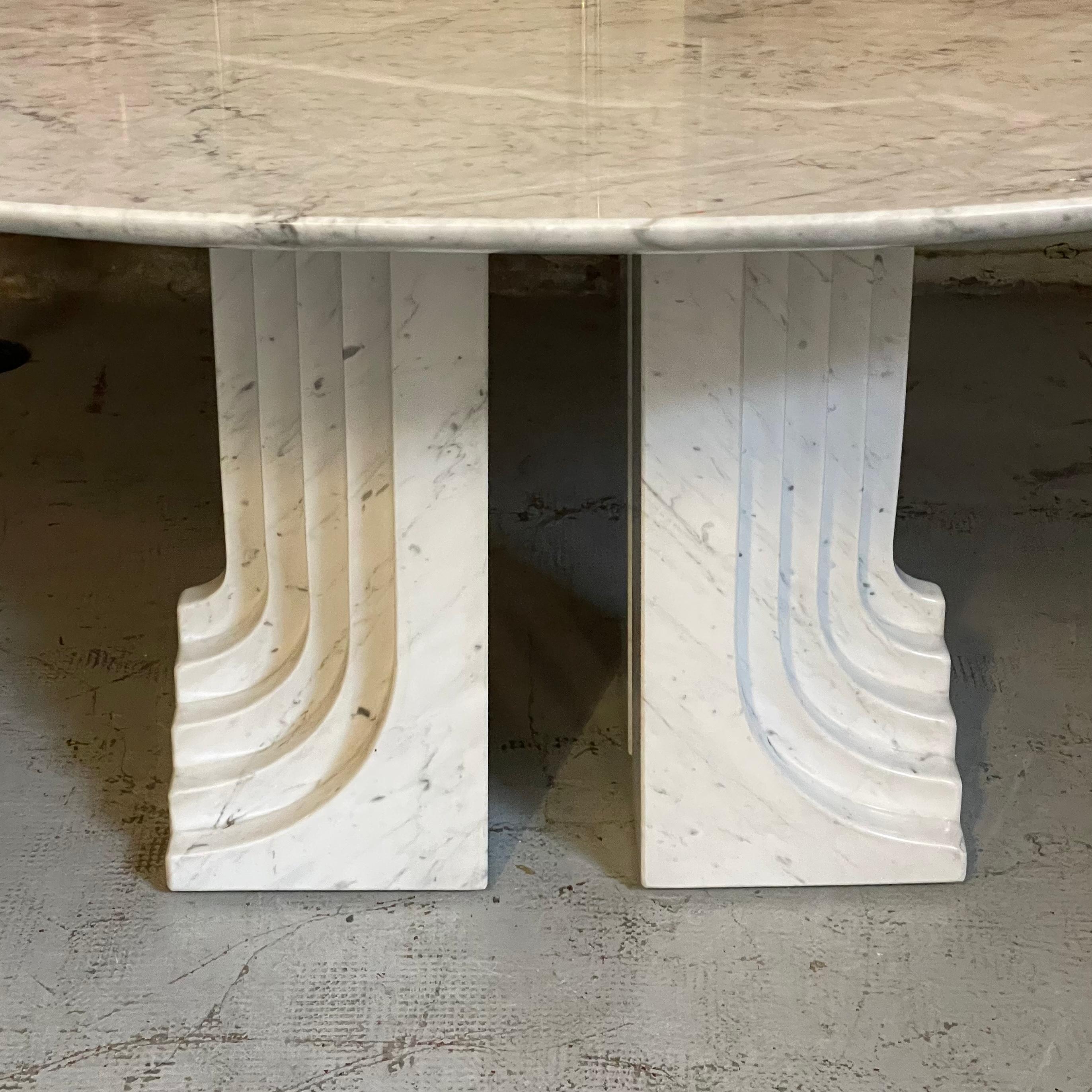 La table Samo de Carlo Scarpa est en marbre blanc. Les pieds sont soutenus par un seul bloc avec des rainures et un plateau ovale épais. Si vous appartenez à la série 