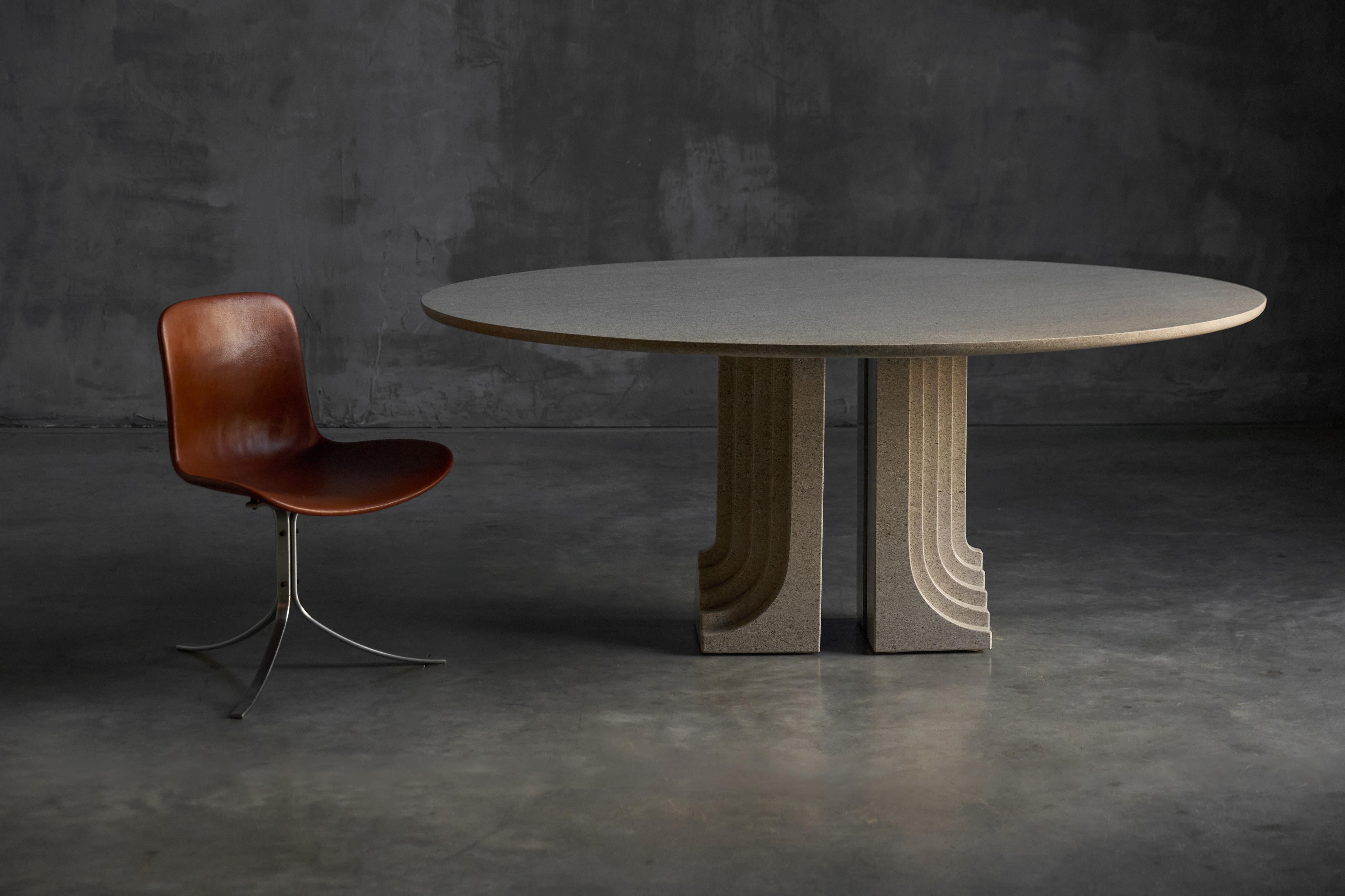 The Samo dining table is a sculptural and architectural masterpiece designed by Carlo Scarpa for Simon Gavina’s Ultrarazionale collection. It features an oval gray granite top that appears to float above two fluted, pillar-like bases inspired by
