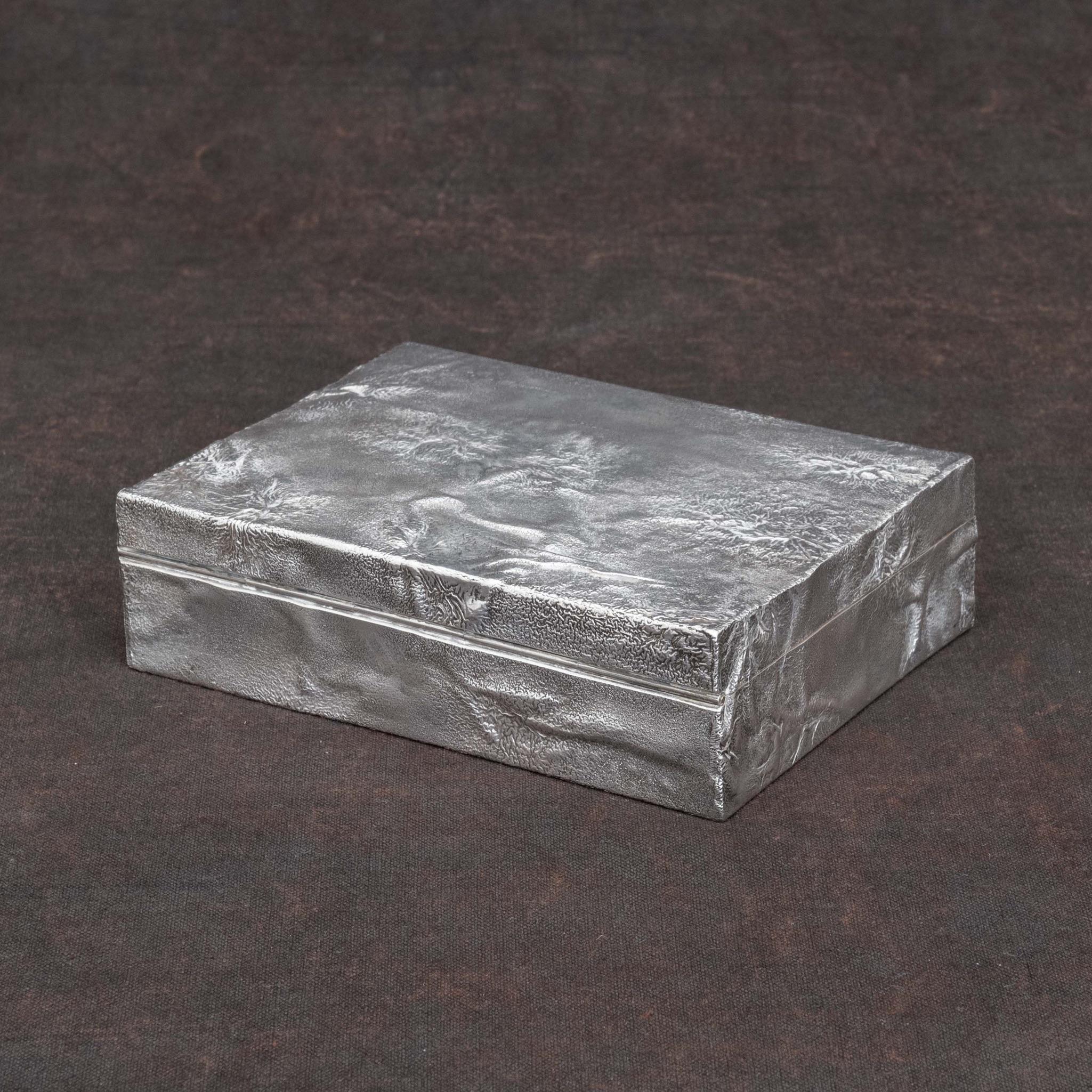 A stunning cigarette box covered with reticulated 'Samorodok' sterling silver. By S.J. Rose and Sons silversmiths. Hallmarked, London 1966.

Dimensions: 14.25 cm/5⅝ inches (width) x 10.5 cm/4¼ inches (depth) x 4 cm/1½ inches (height).

Samorodok is