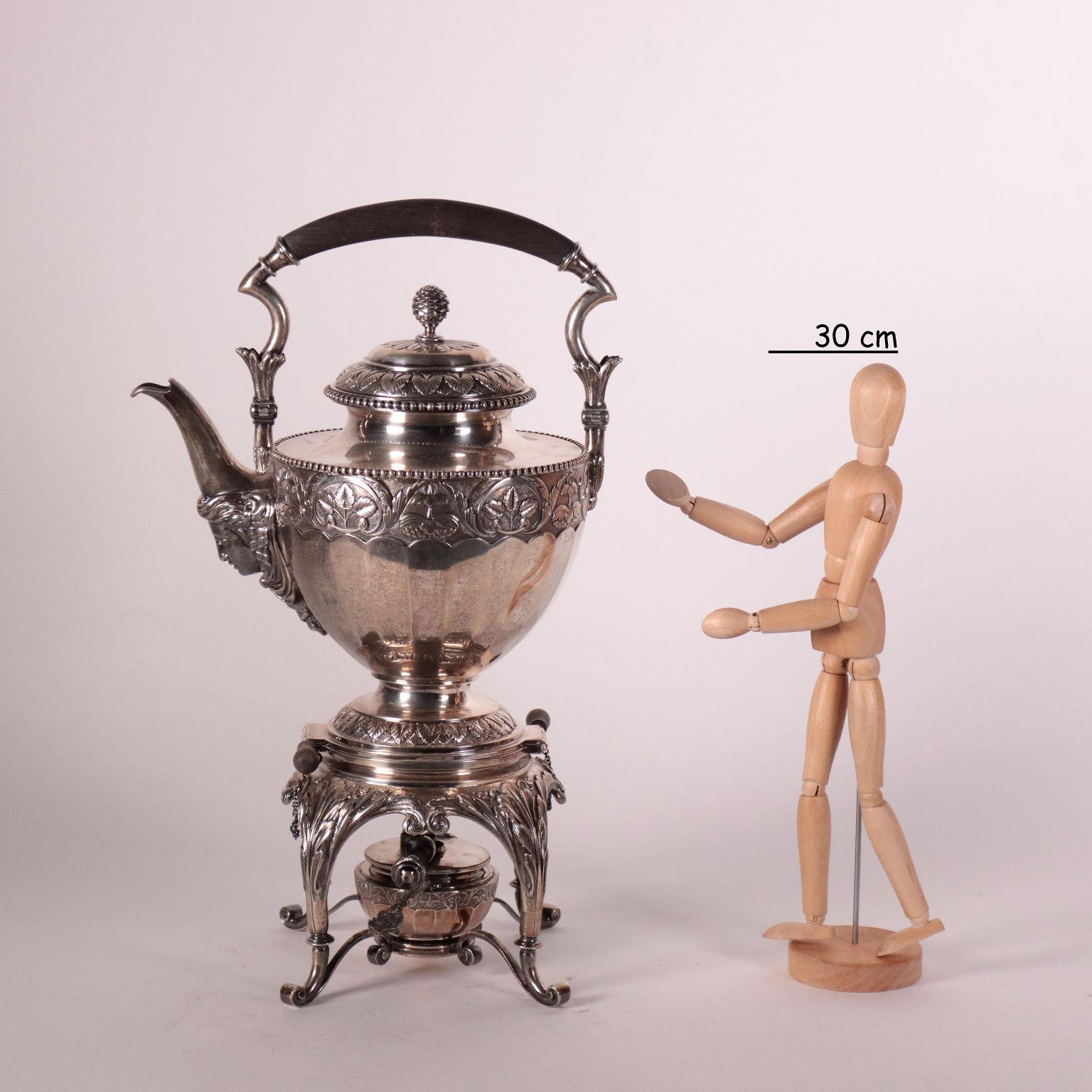 Samovar in embossed and chiselled silver with rich decorations with plant motifs and a female face under the spout. Pine cone shaped lid grip. Brand of the manufacturer engraved. Total gr. 2,500.