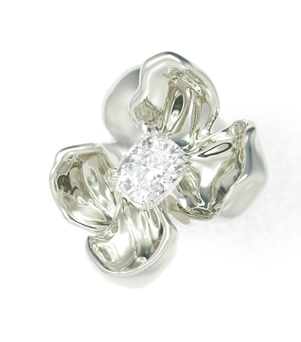 This limited edition Magnolia engagement ring is adorned with a stunning cushion diamond. The weight is 8.59 grams. The flower is larger and heavier than it appears in the photo, and the white gold is exceptionally shiny due to the size and shape of