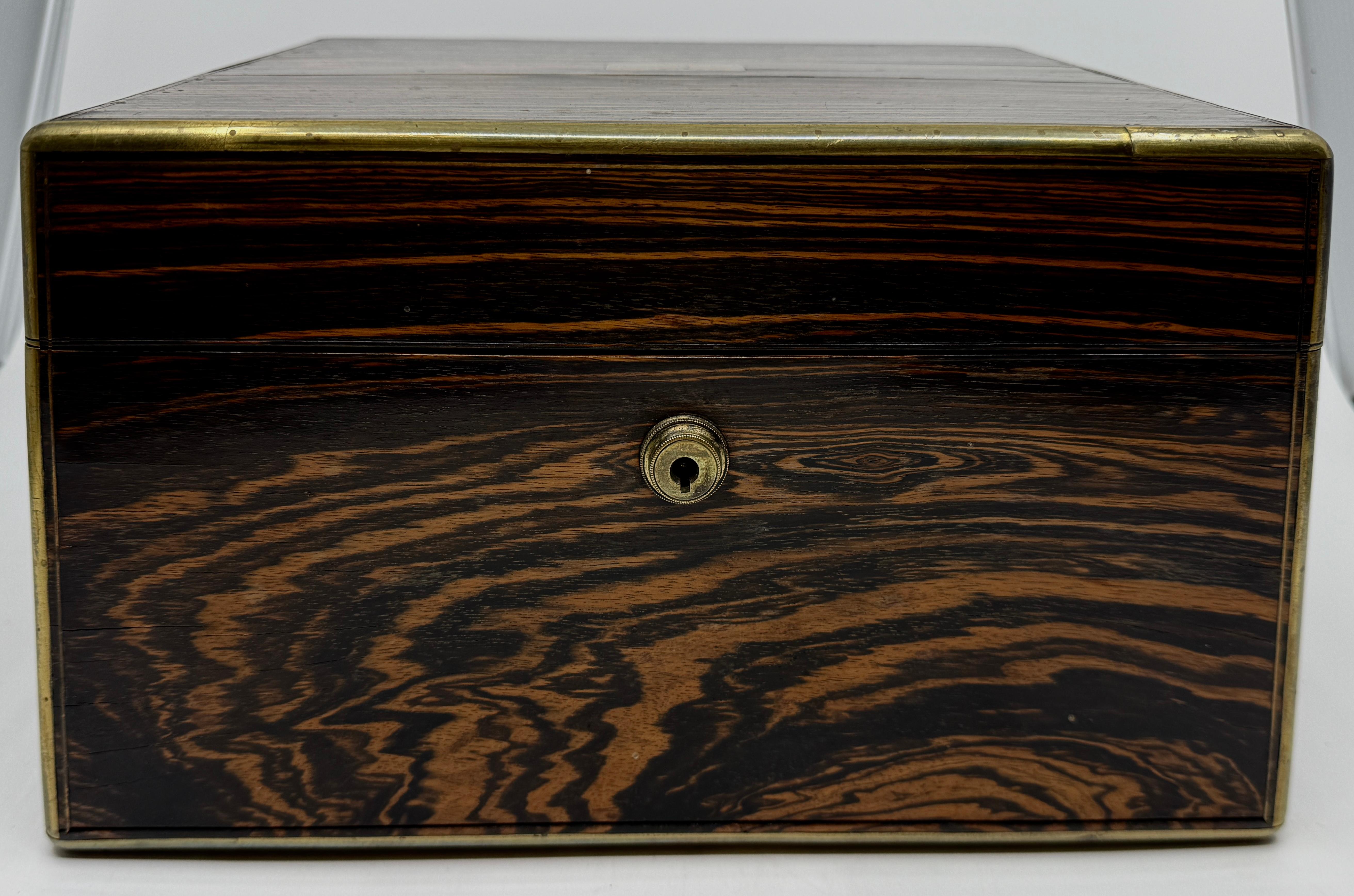 Precioso neceser de madera de calamandro con incrustaciones de latón. Es obra de la prestigiosa firma británica Sampson Mordan & Co, de Londres. Los utensilios tienen asas de nácar y las tapas de las botellas son de Sterling Silevr y llevan el sello