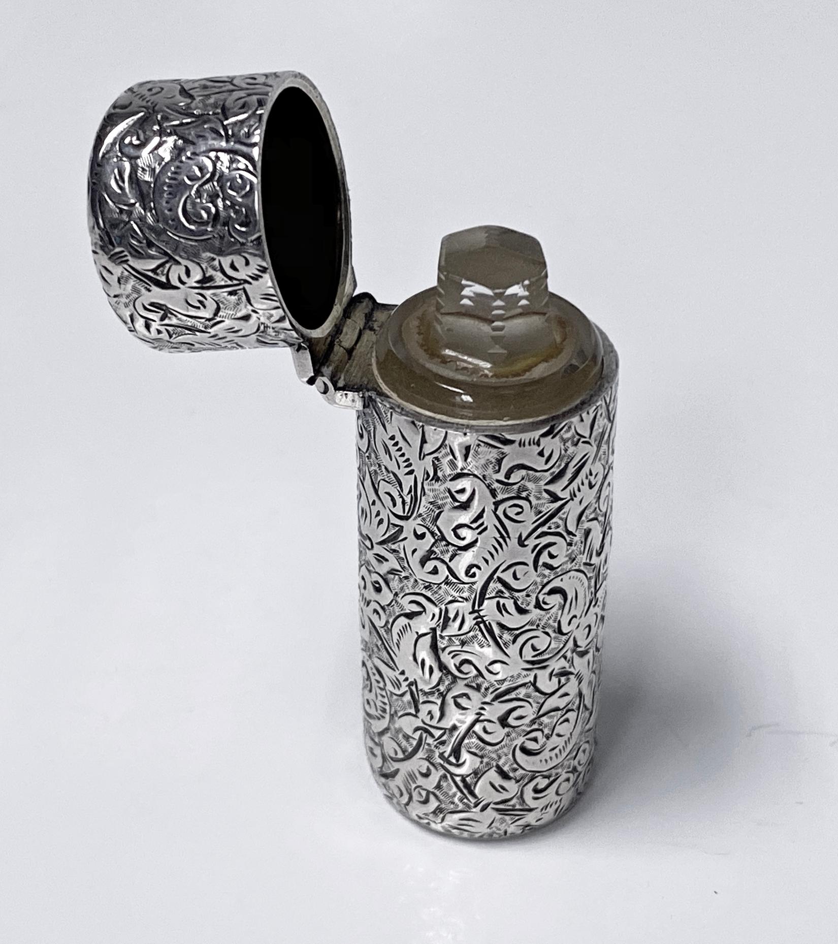 Sampson Mordan Silver Scent Perfume Bottle, London 1888. Cylinder shaped, silver scent bottle, with a hinged top, vacant cartouche, no monograms, glass liner and glass stopper. The bottle is finely engraved with swirling scrollwork and stylized