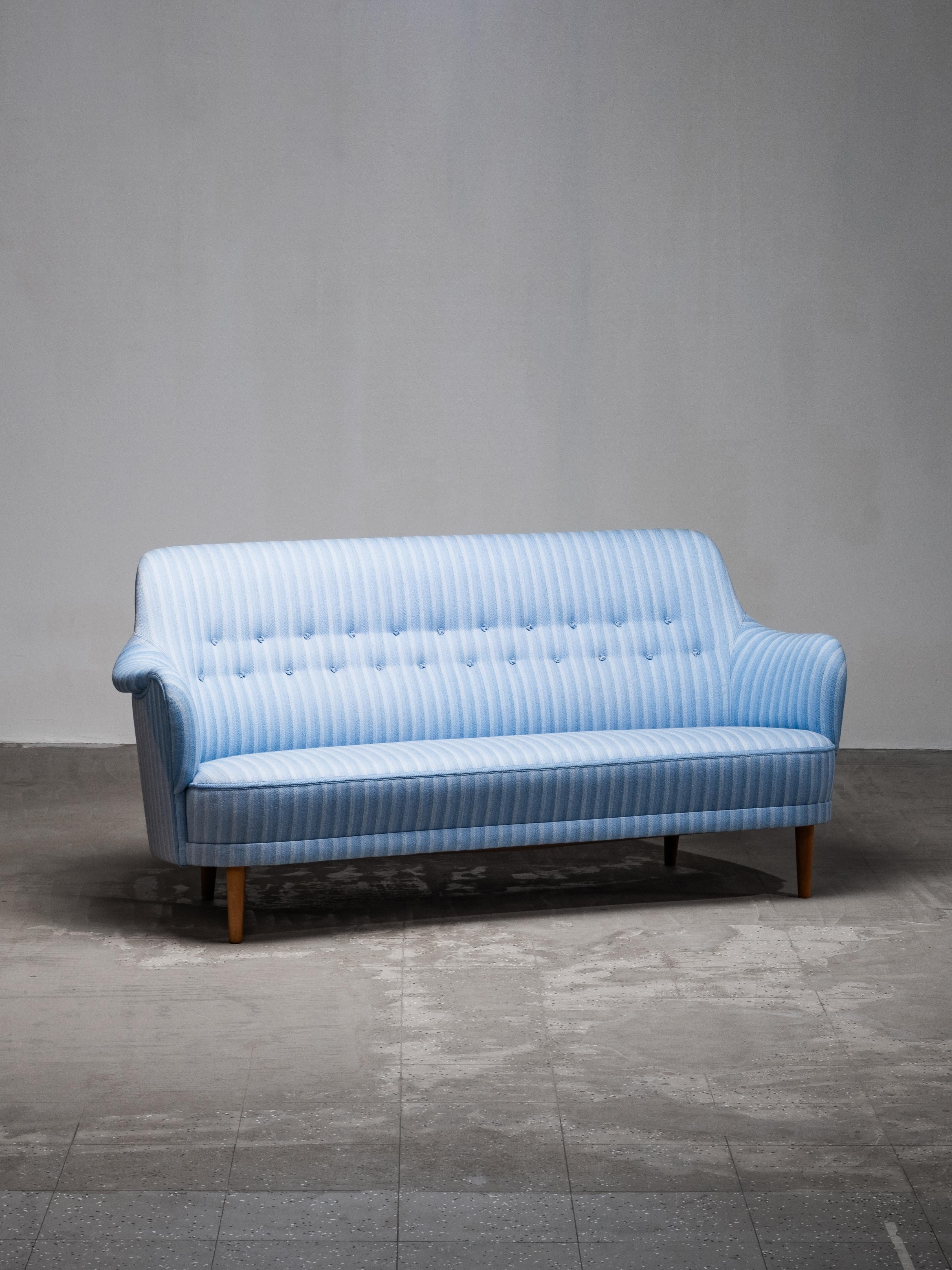 An original “Samsas” three-seater sofa designed by Carl Malmsten and produced by O.H. Sjögren in Tranås, Sweden, during the 1960s. The design captures Malmsten’s signature human-centred approach — soft curves, gentle proportions and an inviting,
